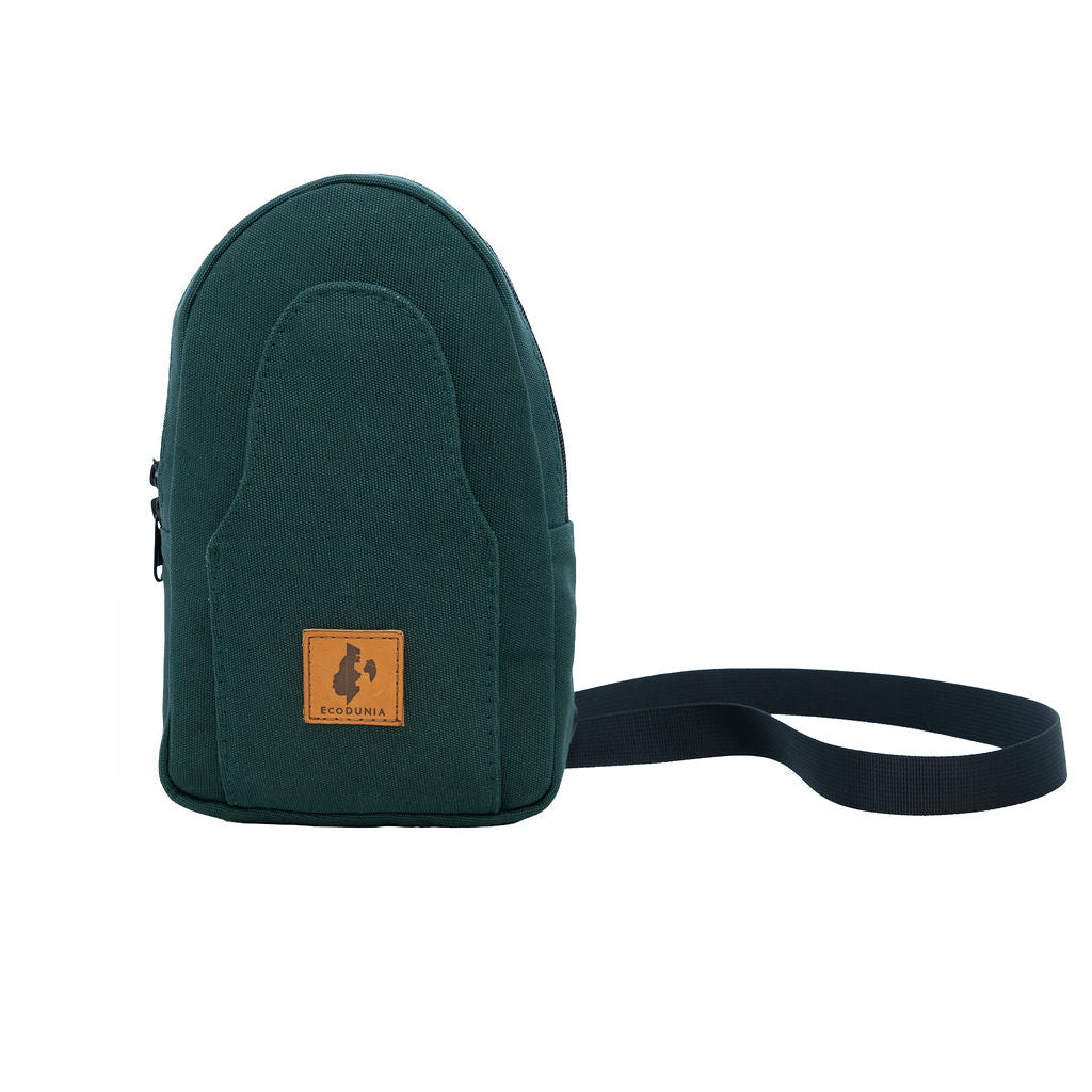 Buru canvas sling bag in forest green worn crossbody #color_forest-green