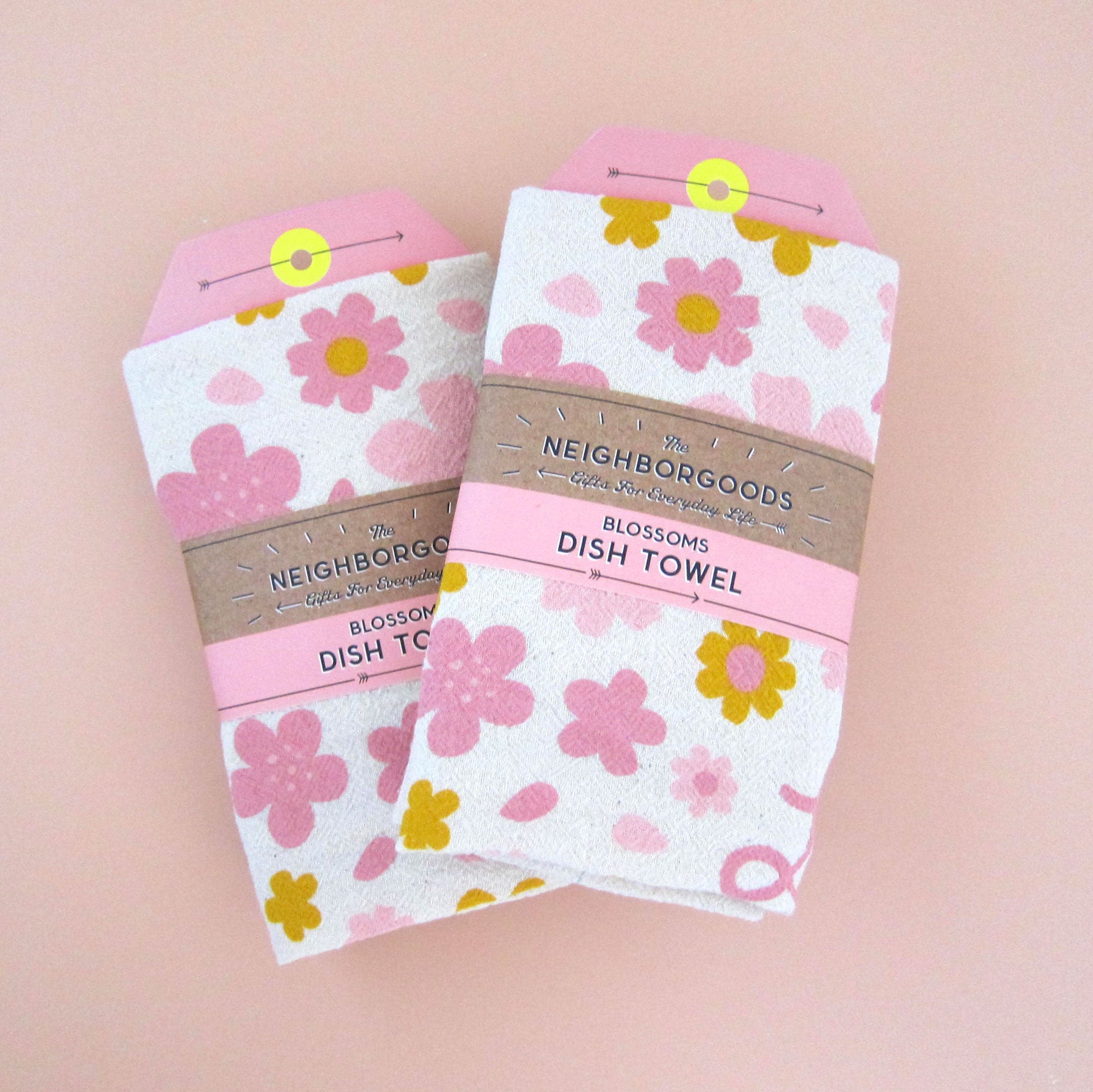Two Cherry Blossom towel souvenirs. Both towels are packaged in The Neighborgoods branded belly band.