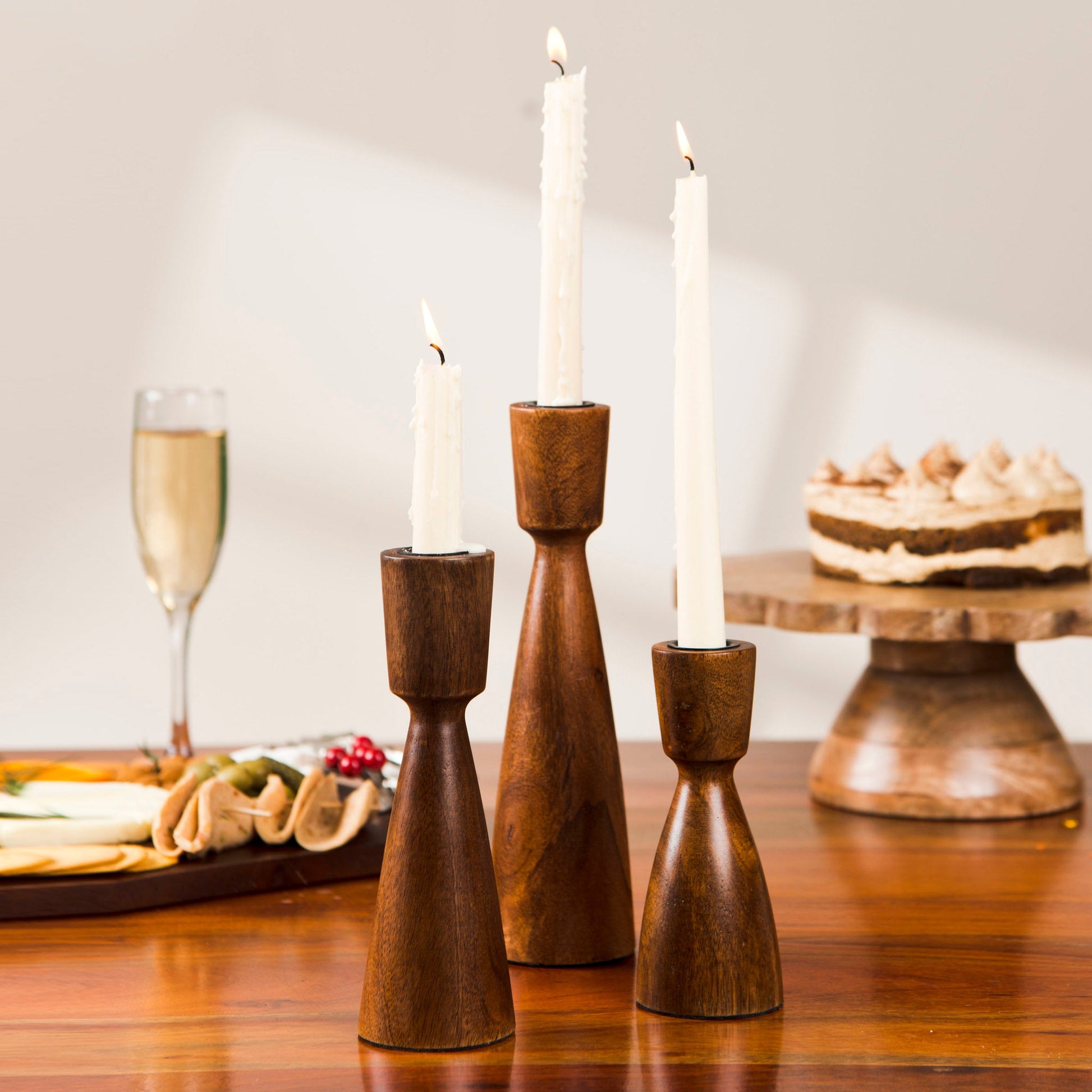 Set of 3 minimalist wooden taper candle holders handcrafted from sustainable mango wood for tabletop decor.