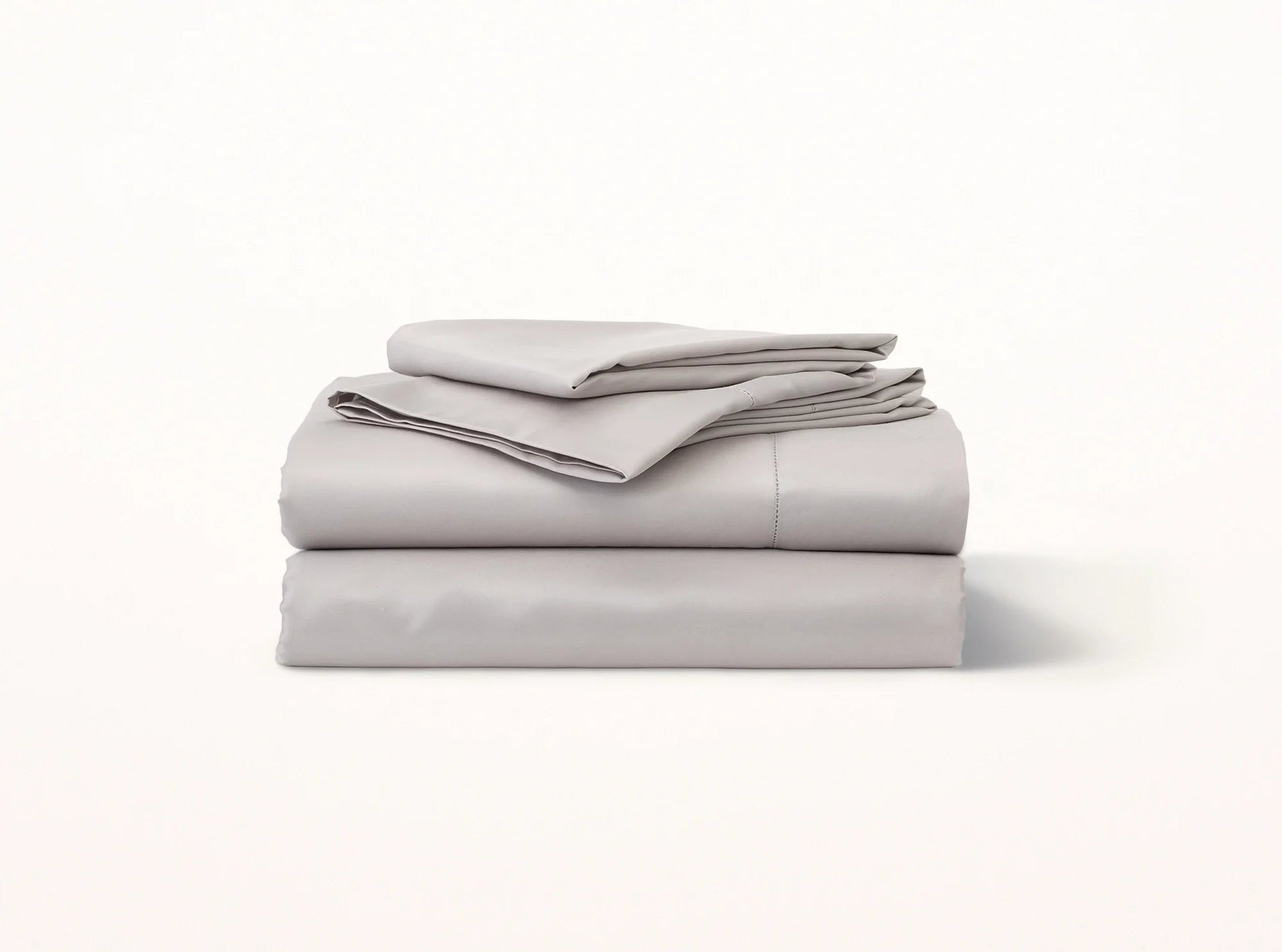 Organic cotton sateen hemstitched sheet set in quiet gray on bed - luxury bedding made in Portugal