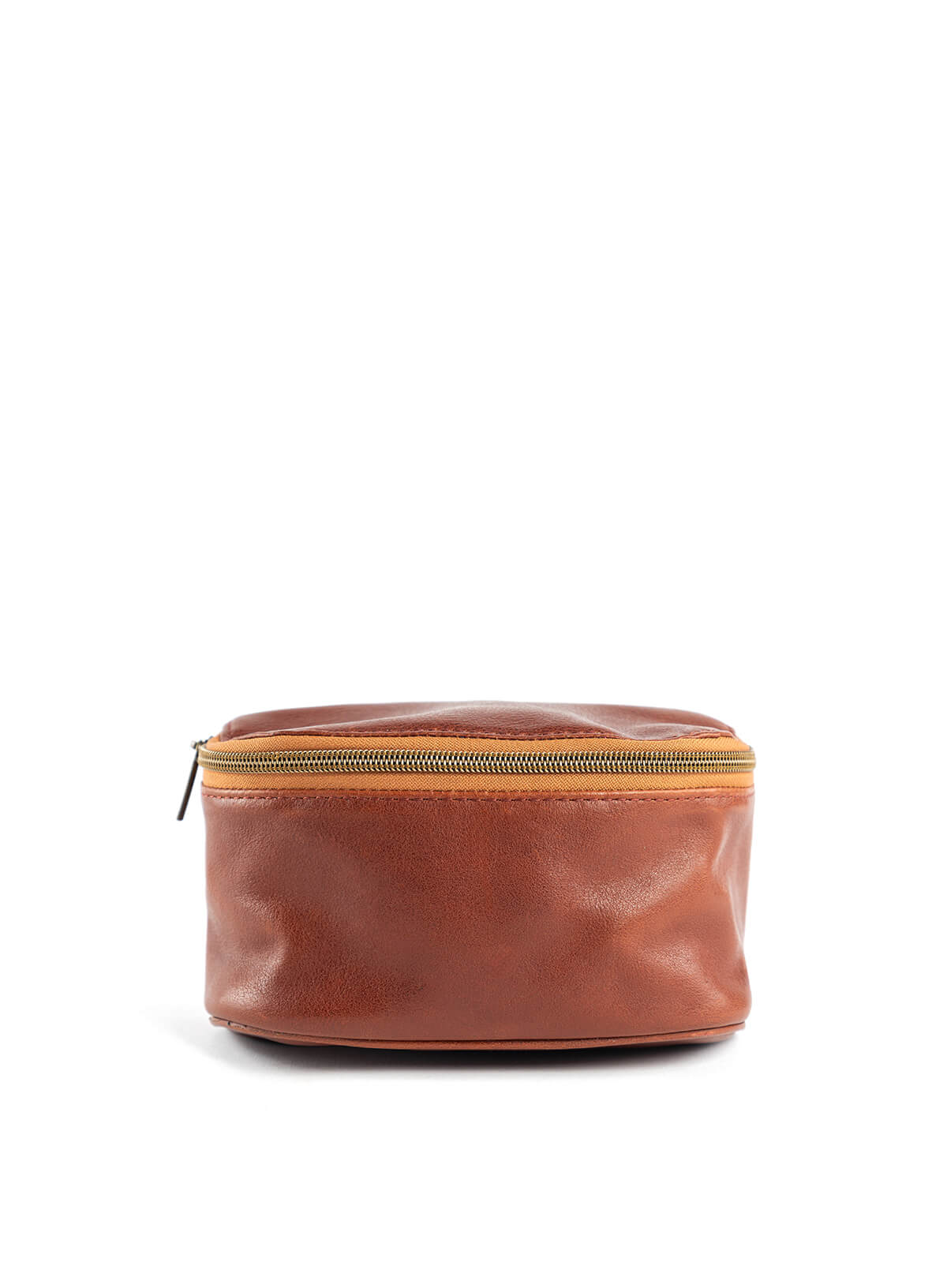 Hip bag in mahogany from the fall/winter collection held by model leaning on a table. 