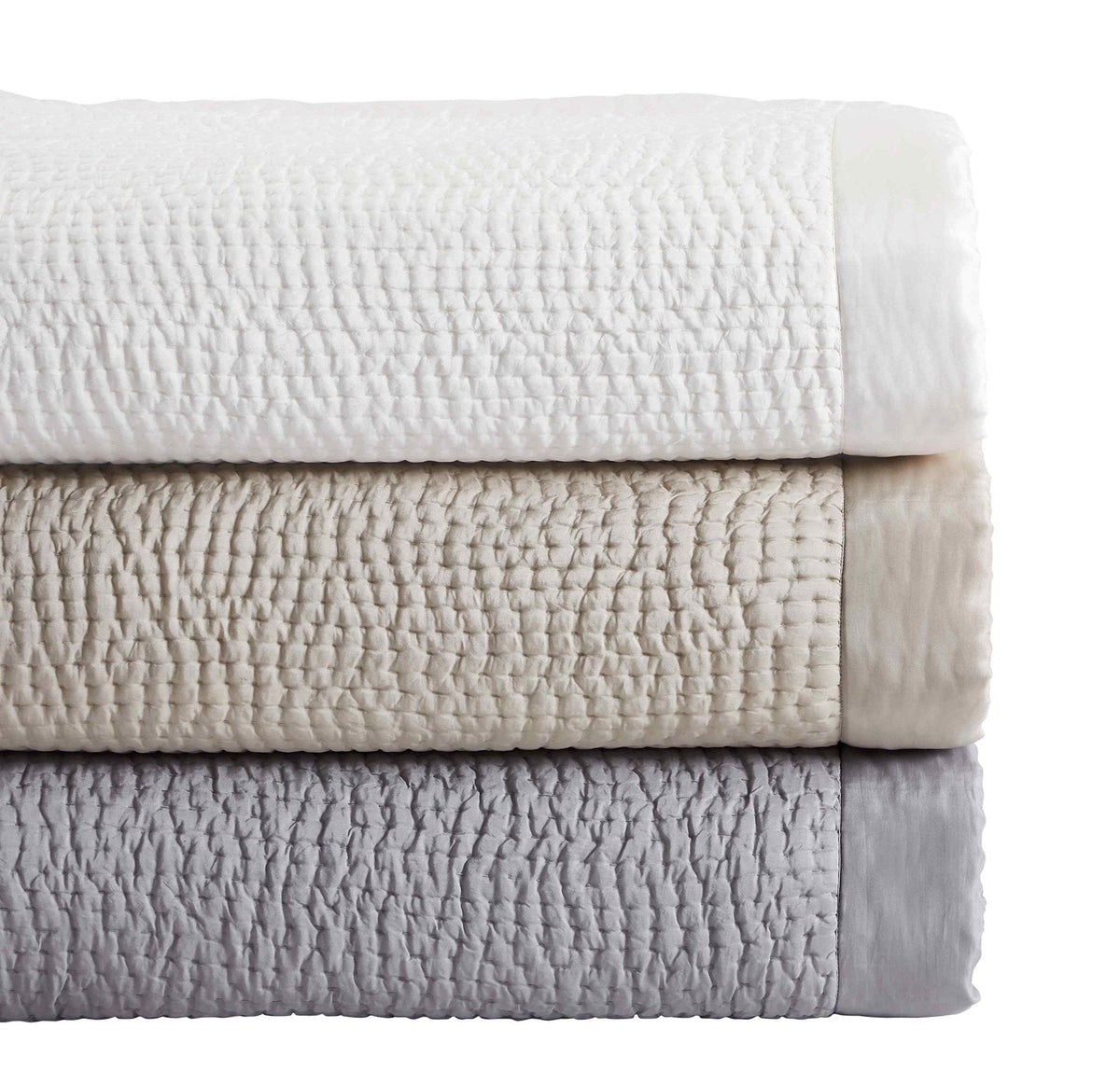 CL-165-X_2|Stacked luxurious quilted blankets in white, beige, and grey, featuring soft textures and satin edges for versatile decor.