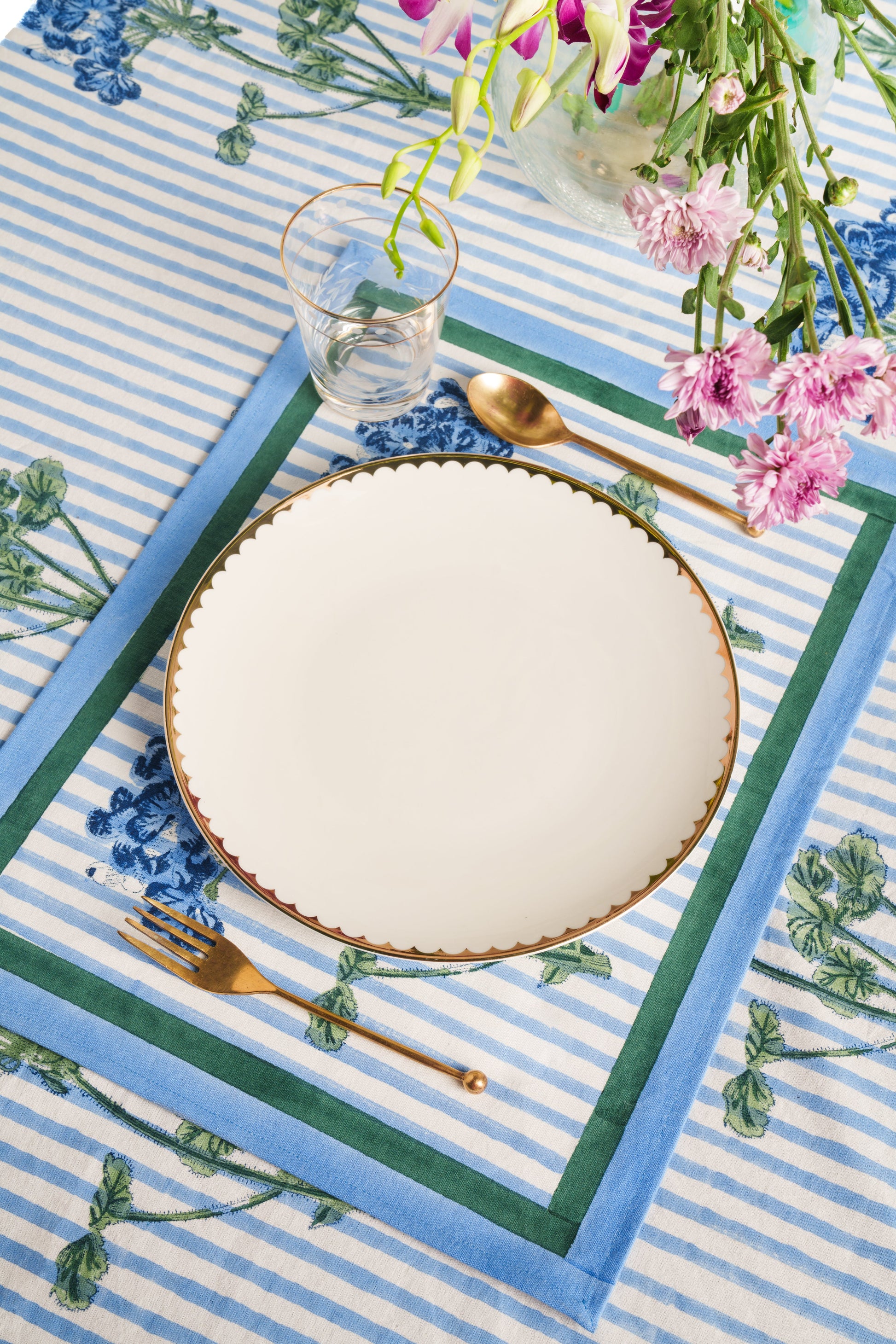 Blue striped hydrangea blockprint placemat with gold-rimmed plate and utensils