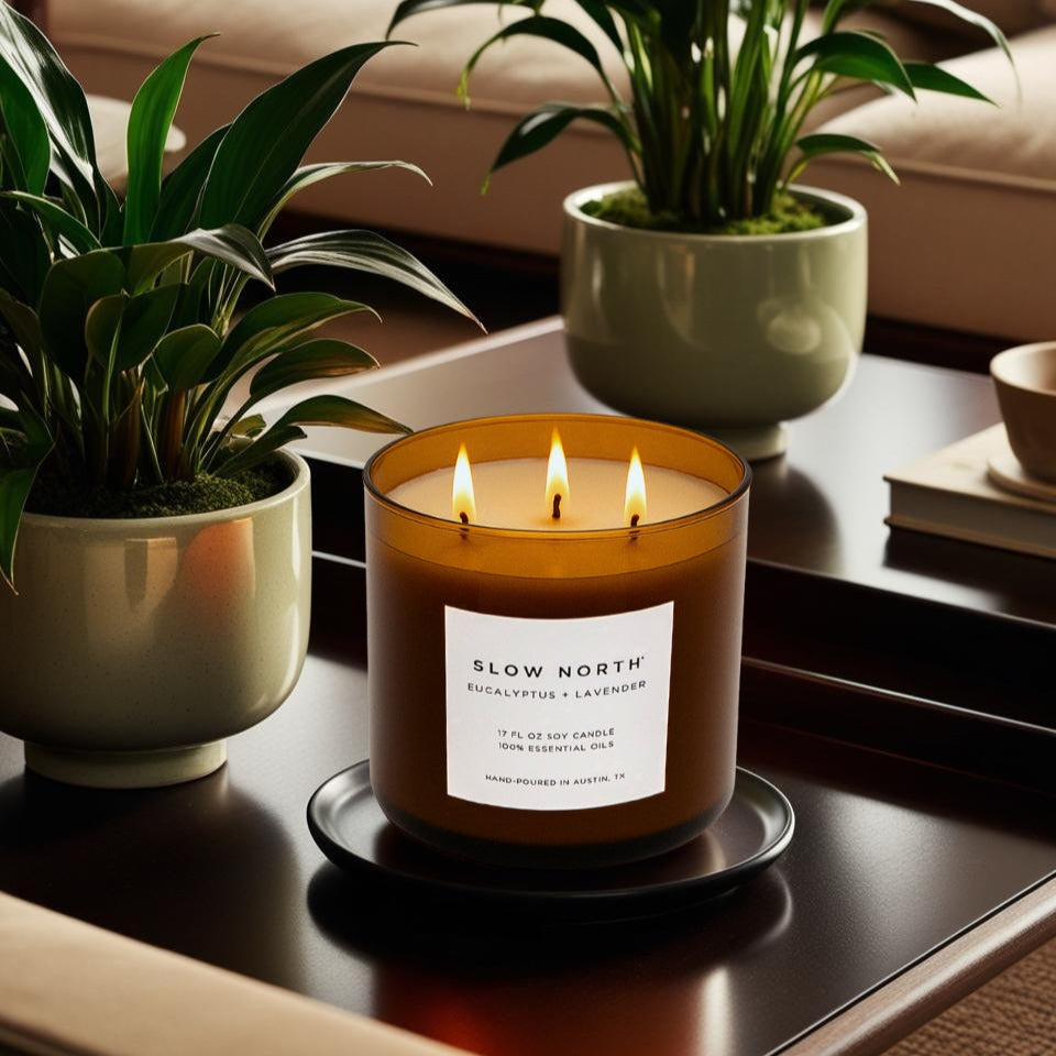 large 3-wick natural candle sitting on a cozy coffee table