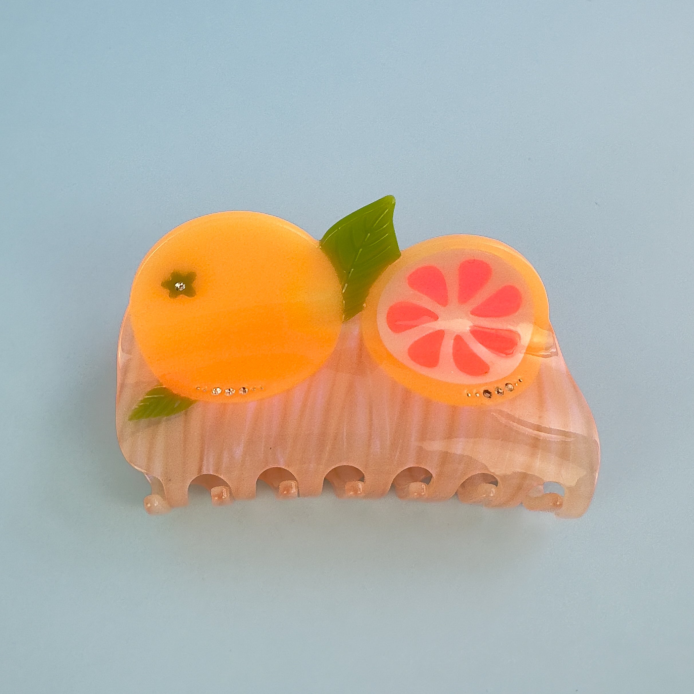 California pomelos orange juicy citrus hair claw clip from Centinelle. Handmade on cellulose acetate, with splice technique, exquisite miniature details and crystals, that are tied directly to its value and make them unique and special. 