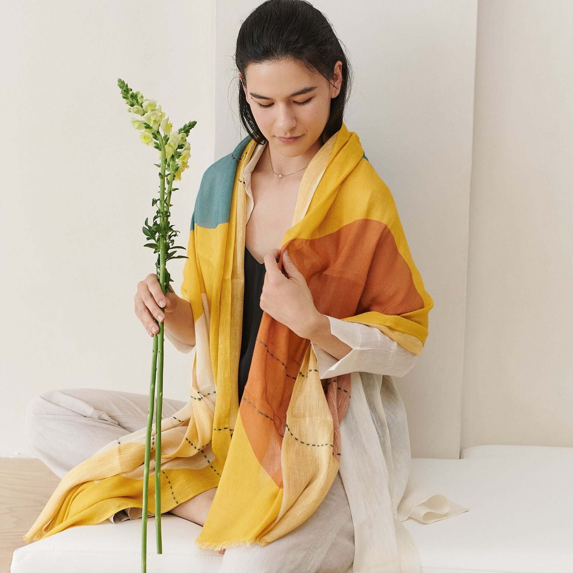Cirq Sun Yellow Green Circle Pattern Hand Embroidered  Linen Silk Handloom Scarf worn by a model holding a flower.