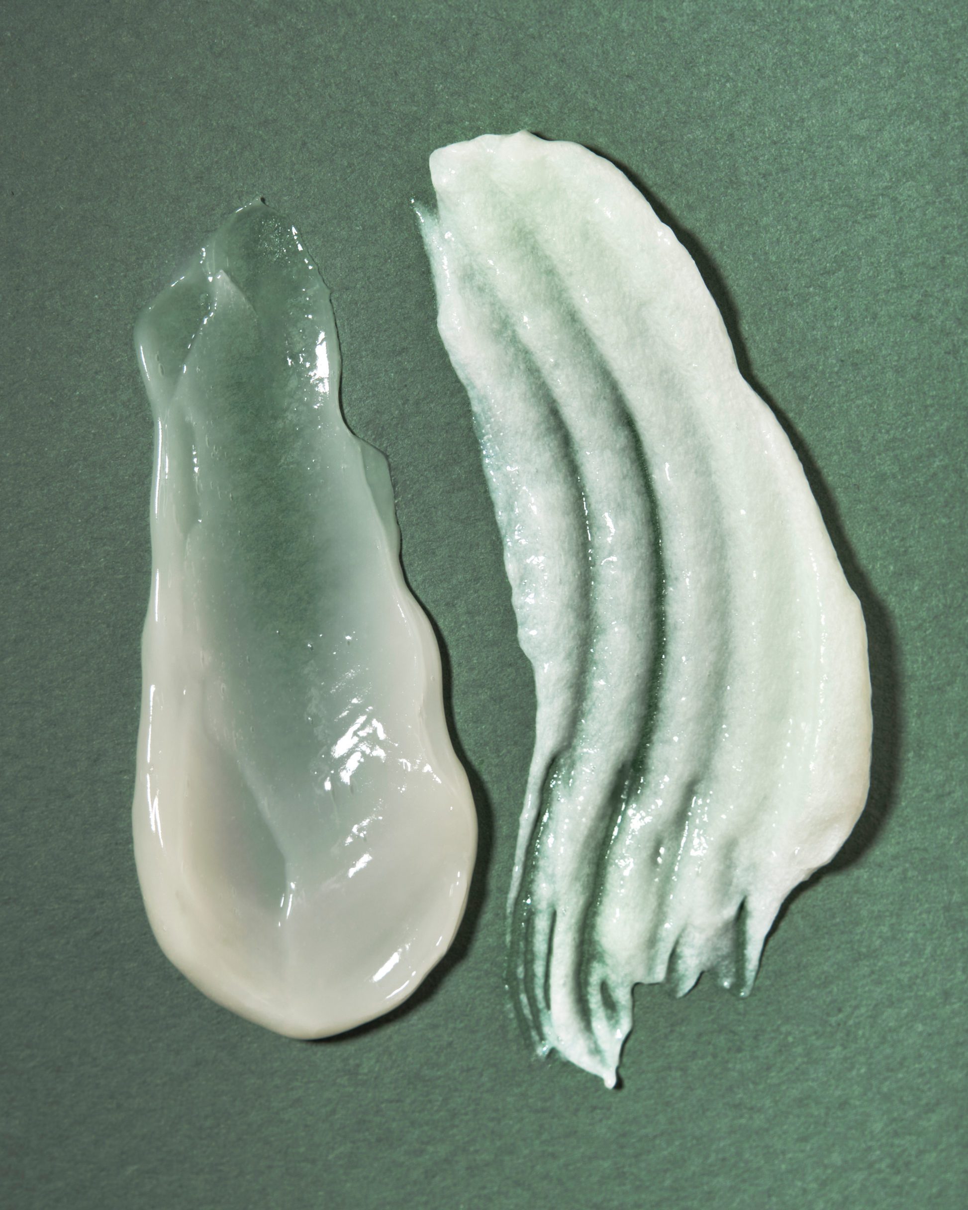 Two swatches of a white cream on a green background