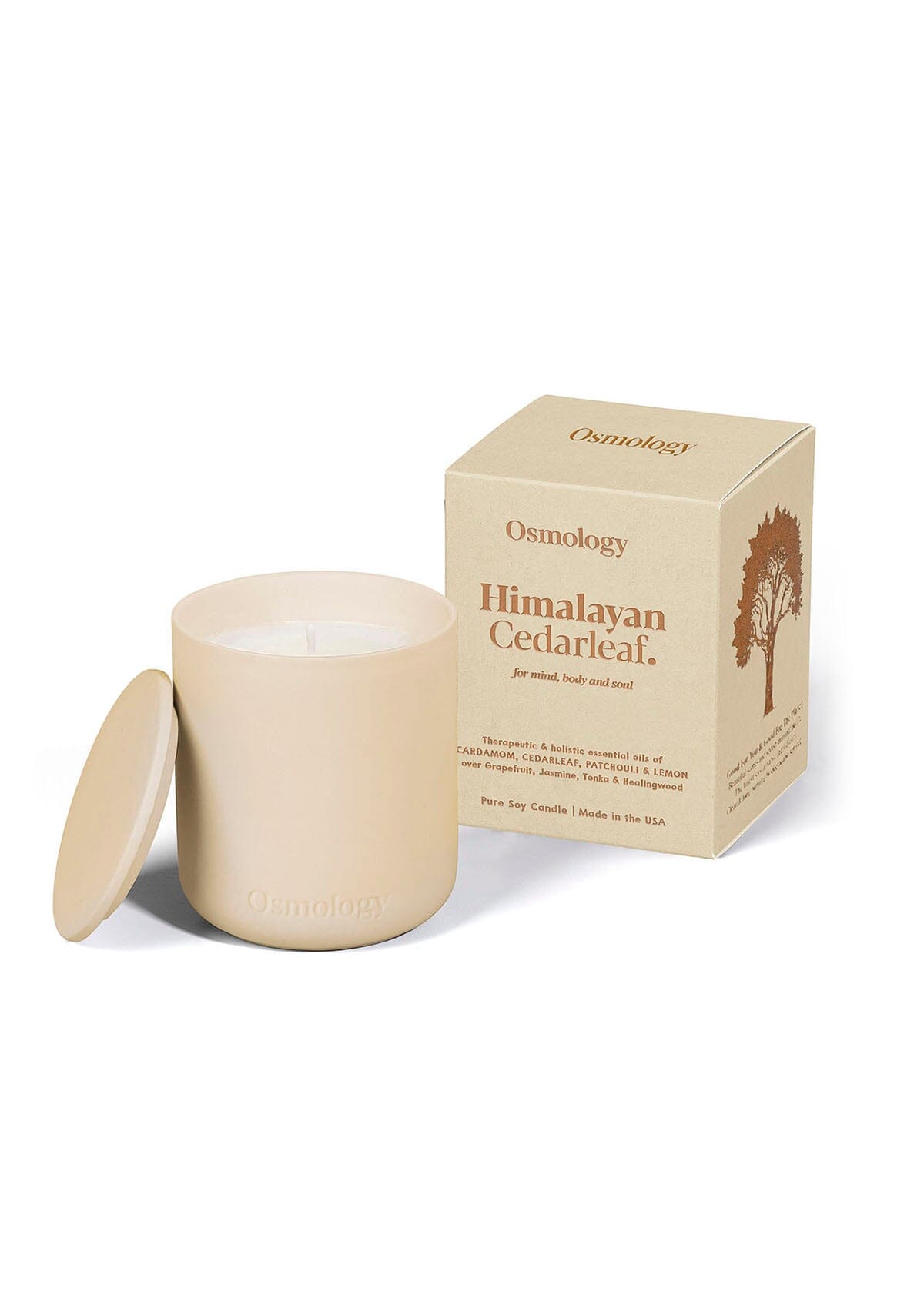 Cream ceramic candle with matching lid next to product packaging on cream background