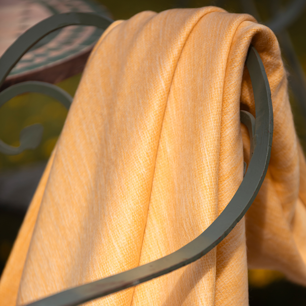 golden yellow throw blanket draped on chair