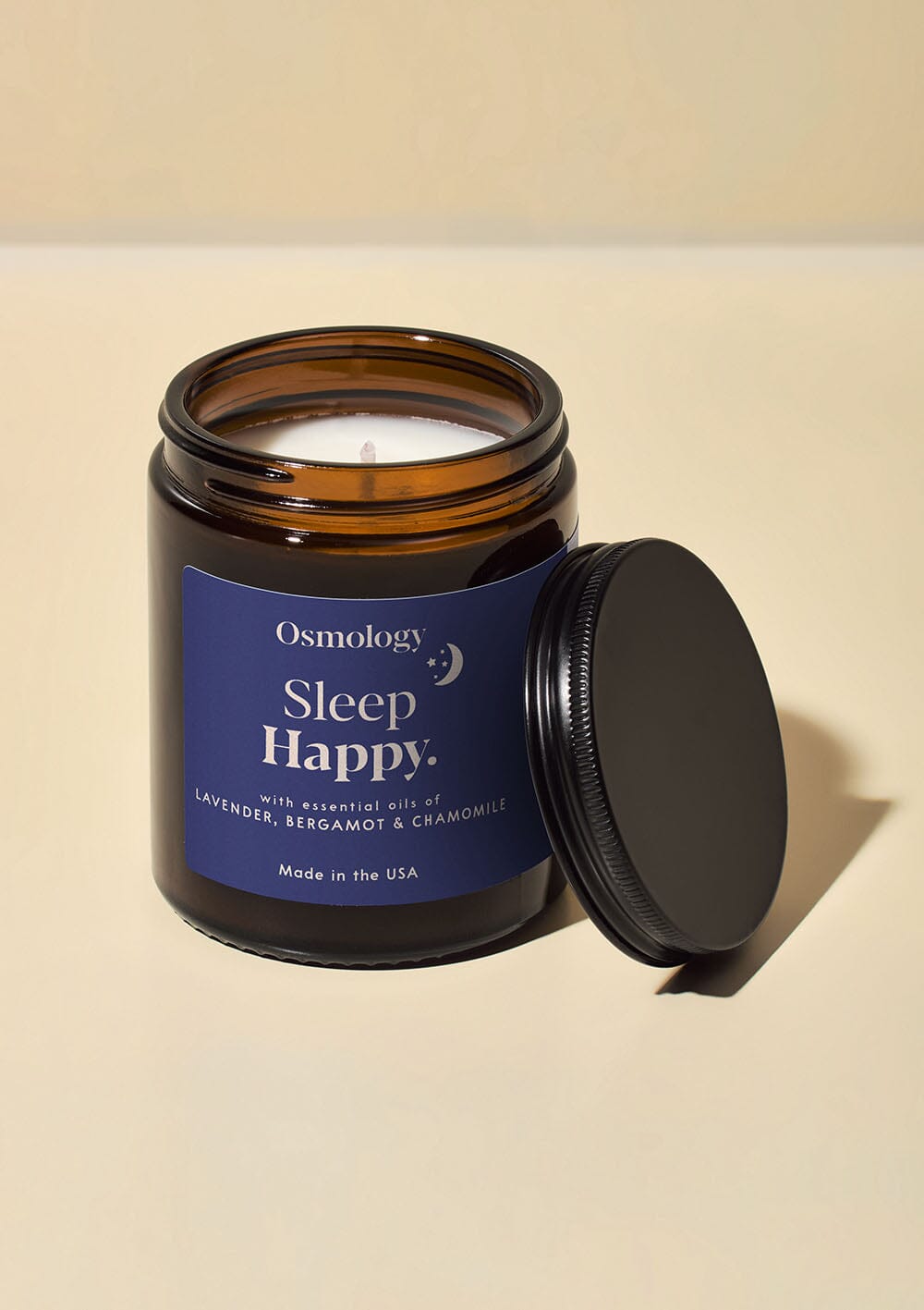 Osmology Sleep Happy jar candle with open lid on white background