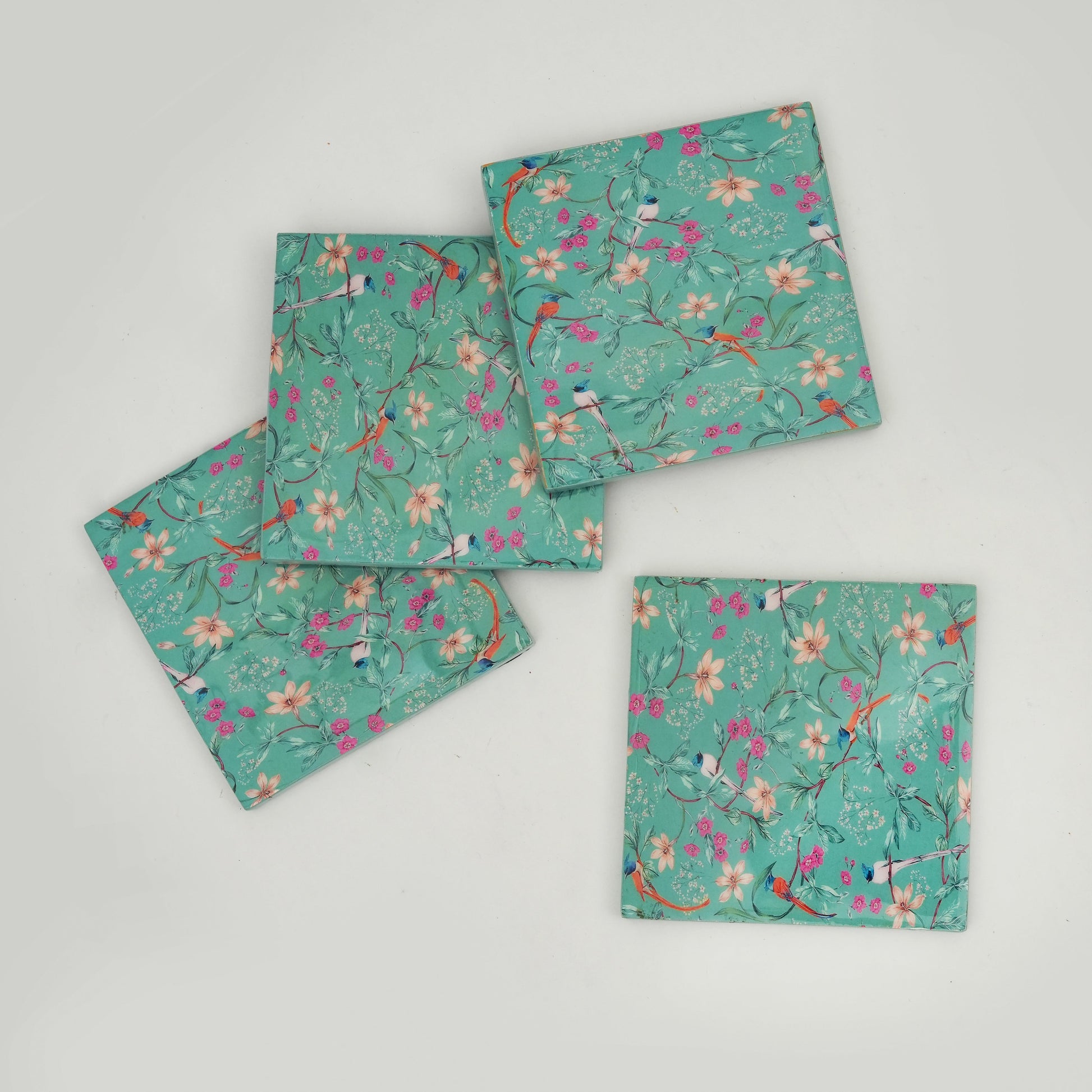 Set of four floral-patterned napkins on a gray background