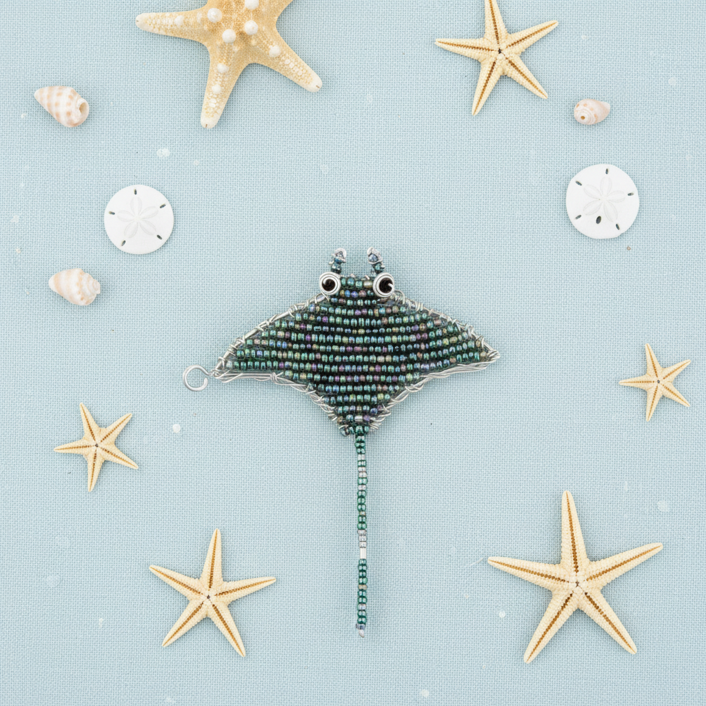 Manta Ray Keyring flat lay on blue linen with starfish and sand dollars