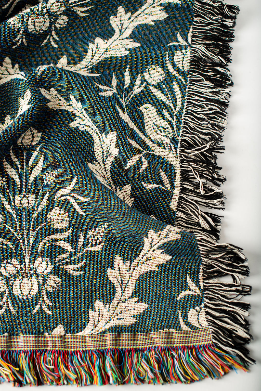 Close-up of Isobel Thistle teal and cream floral botanical jacquard woven blanket with fringe
