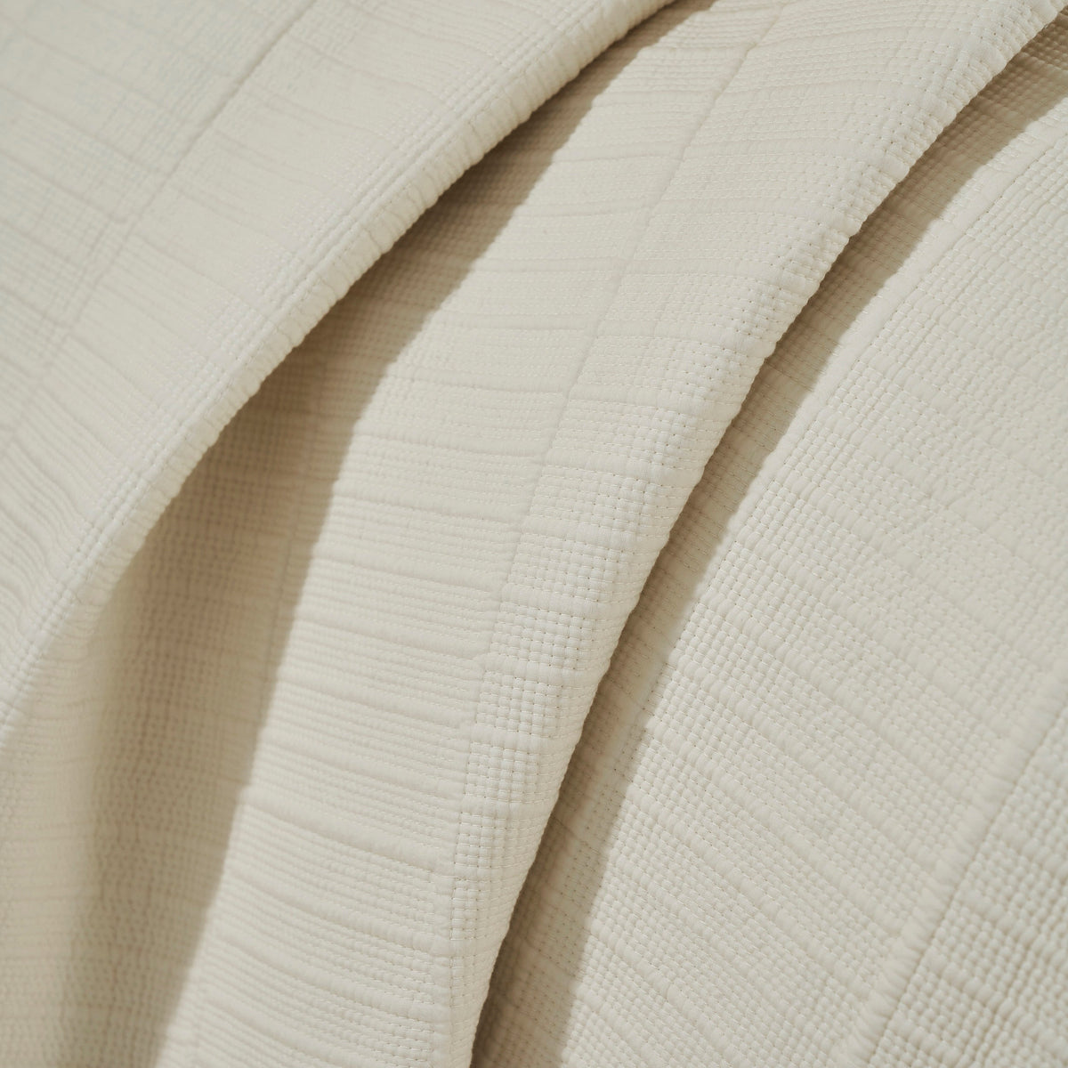 CL-271-9496_8|Close-up of a luxurious cream coverlet, showcasing its intricate woven texture with subtle stripes and square patterns.
