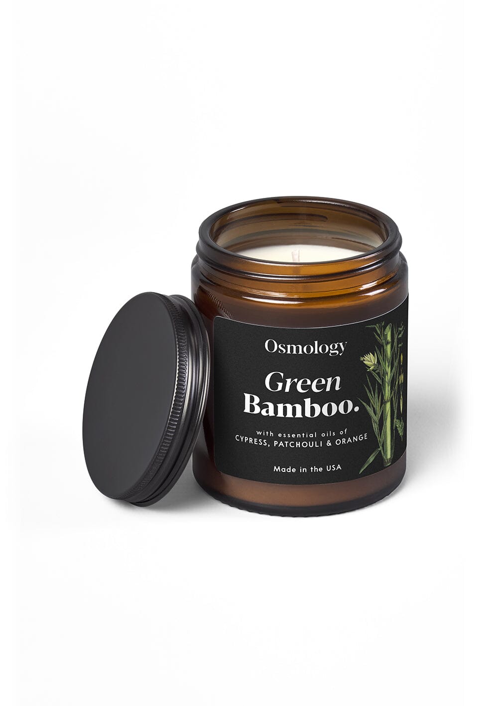 Osmology Green Bamboo jar candle with open lid on cream bcakground