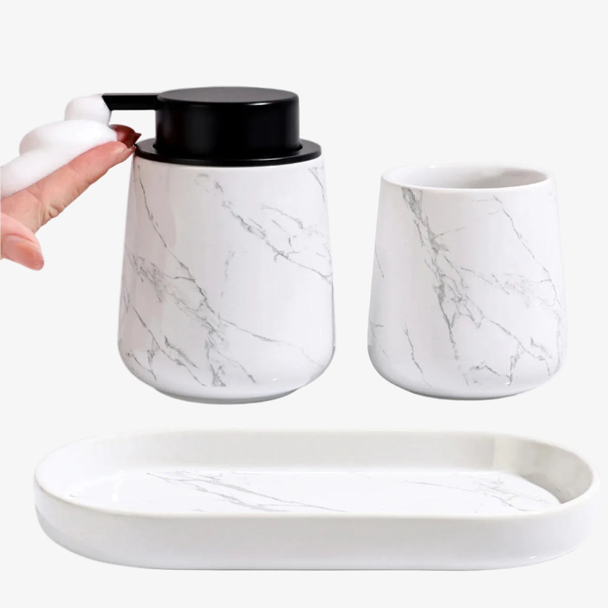 BosilunLife Marble 3-piece recycled eco-clay bathroom set featuring a foaming soap dispenser dispensing white foam into a hand, alongside a matching tumbler and oval vanity tray.