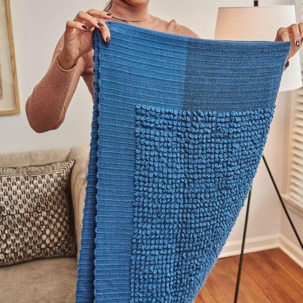 Macaroon Midnight Dark Blue Textured Merino Handloom Throw held by a woman showcasing its unique texture and color.