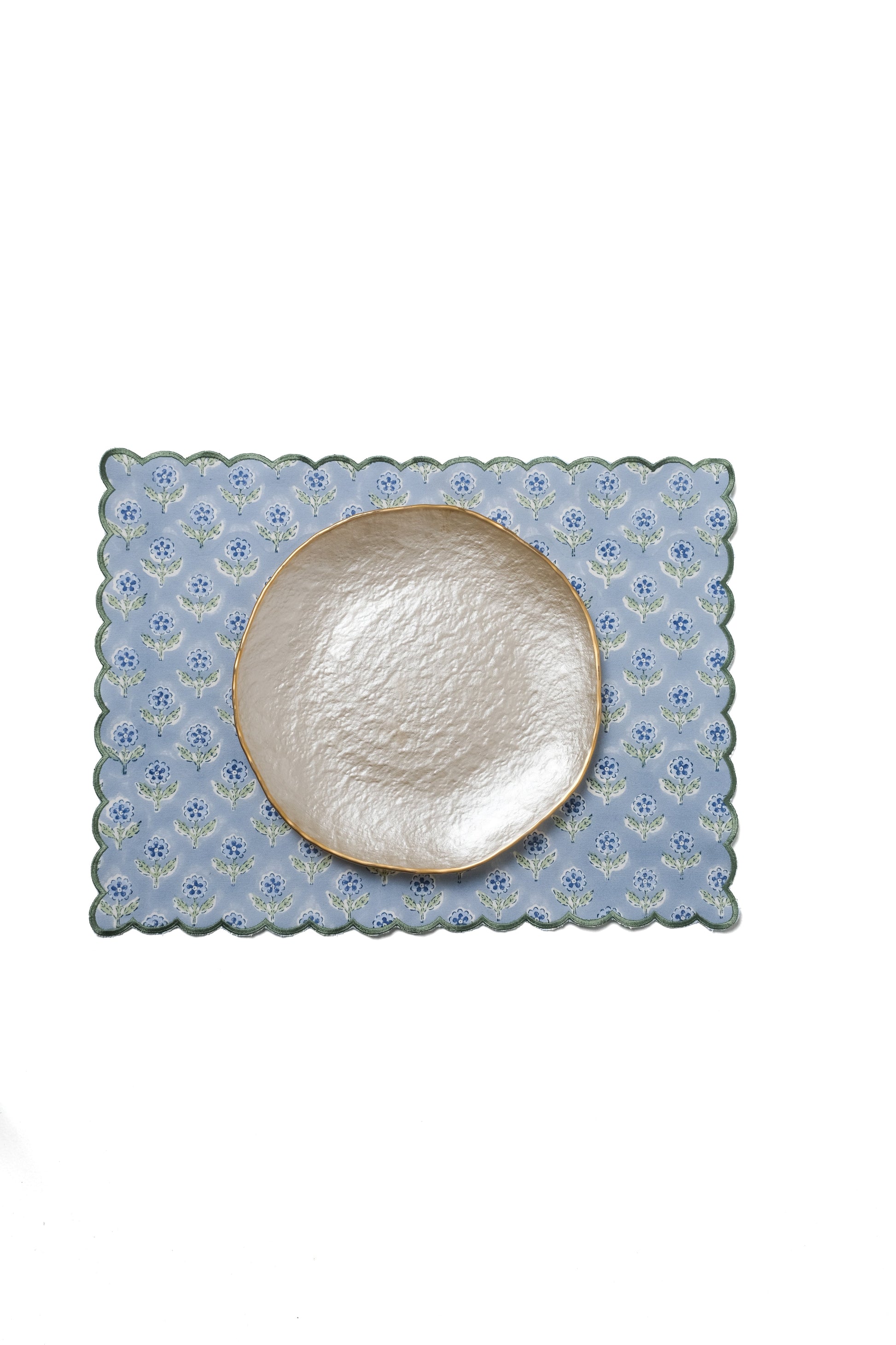 Blue scalloped placemat under decorative plate from Inner Child