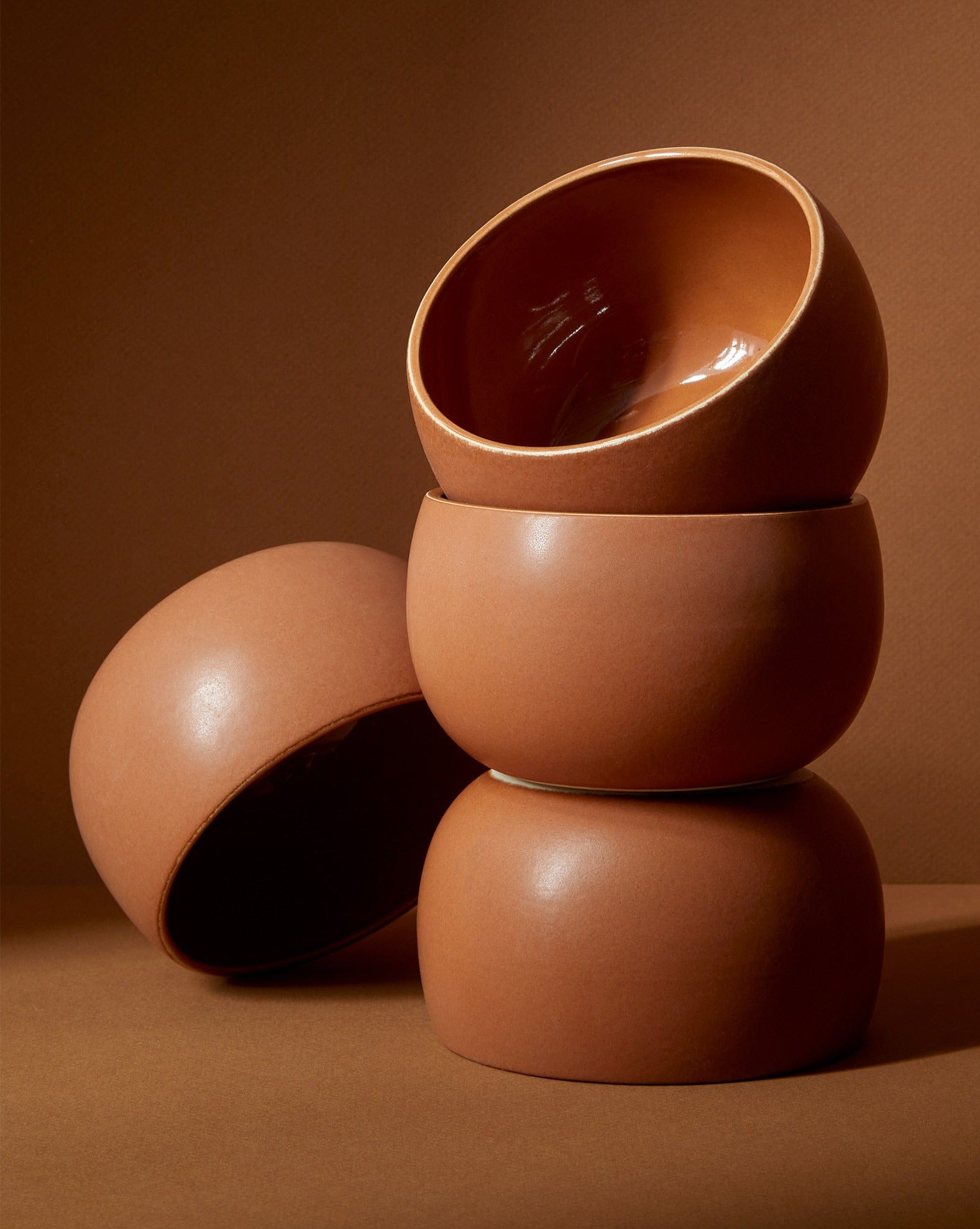 A stack of three white stoneware soup bowls of different sizes on a neutral background.