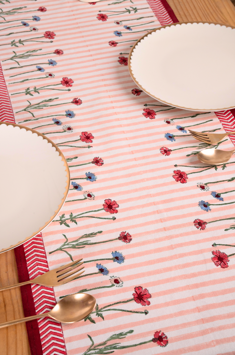 Pink striped wildflower tablerunner with red/blue blooms, gold plates, wooden table - Inner Child design