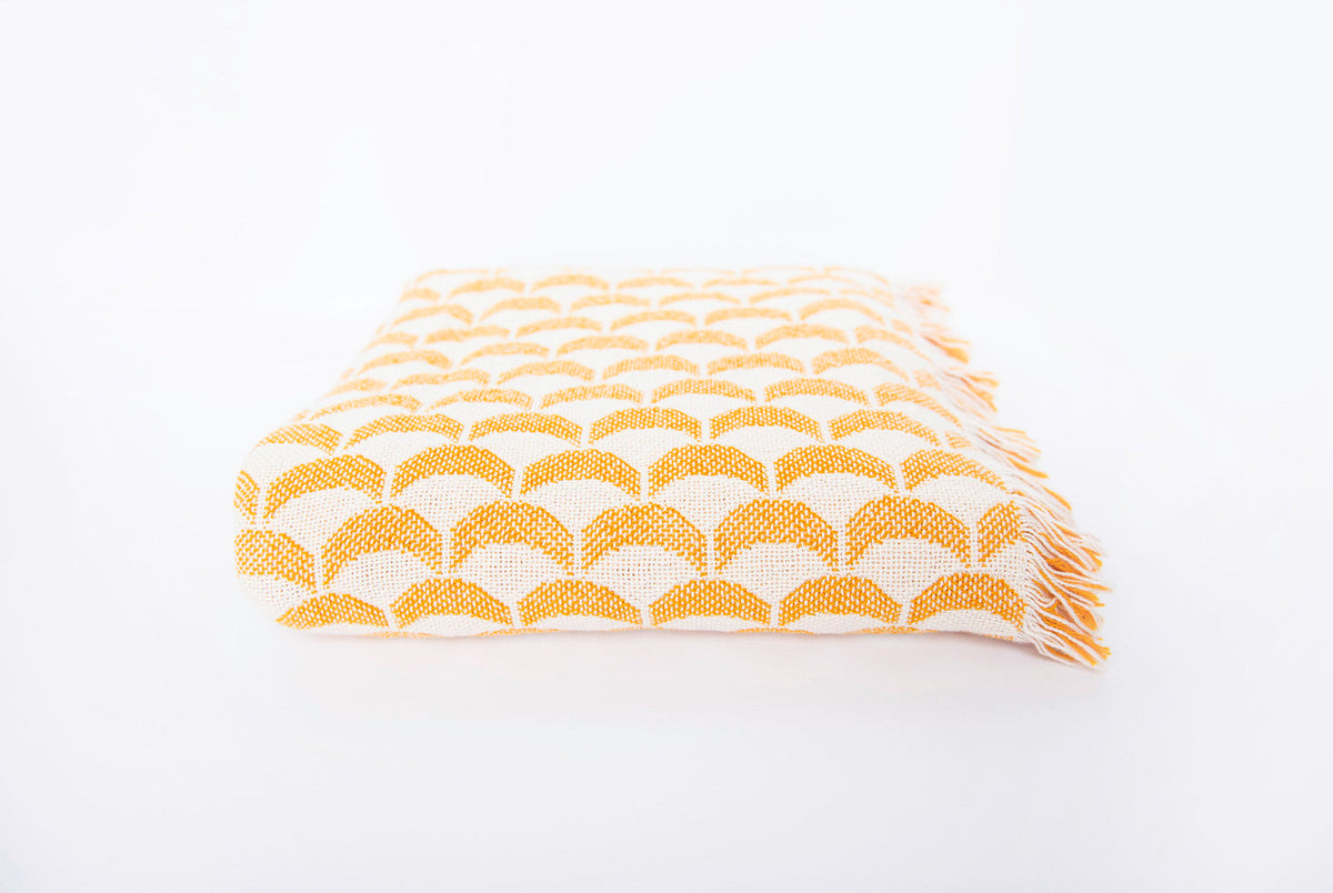 Side view of folded Sadie golden yellow scallop woven throw with fringe