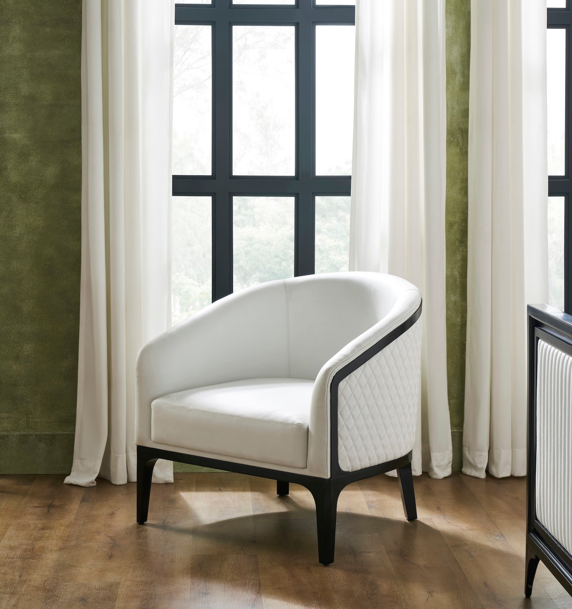 FN-5204-343329_1|White leather armchair with quilted side panel and dark wood frame in a room with green walls, luxury furniture.