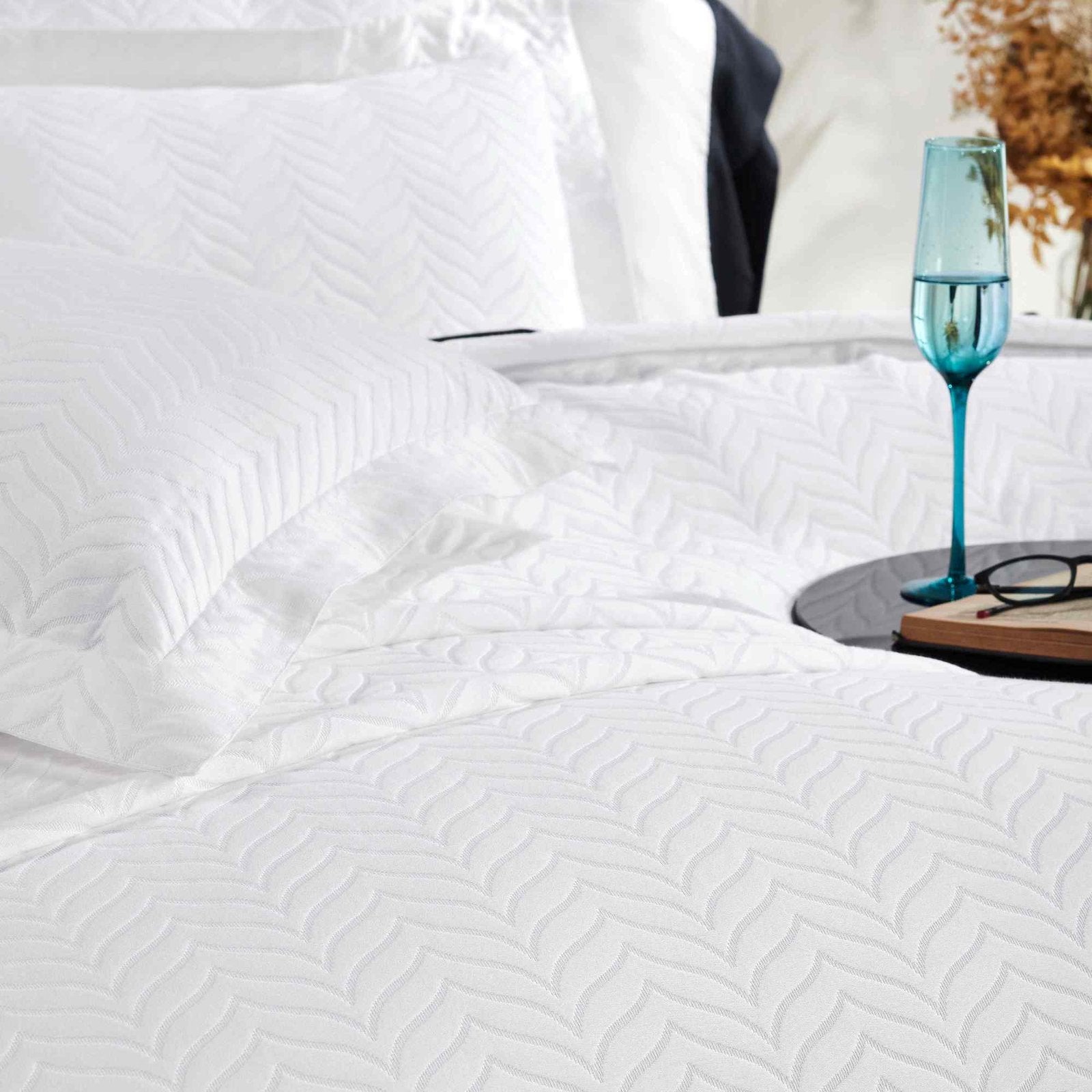 CL-194-9496_3|Detailed view of a crisp white chevron quilted coverlet with matching pillow, highlighting its modern design and soft, comforting texture.