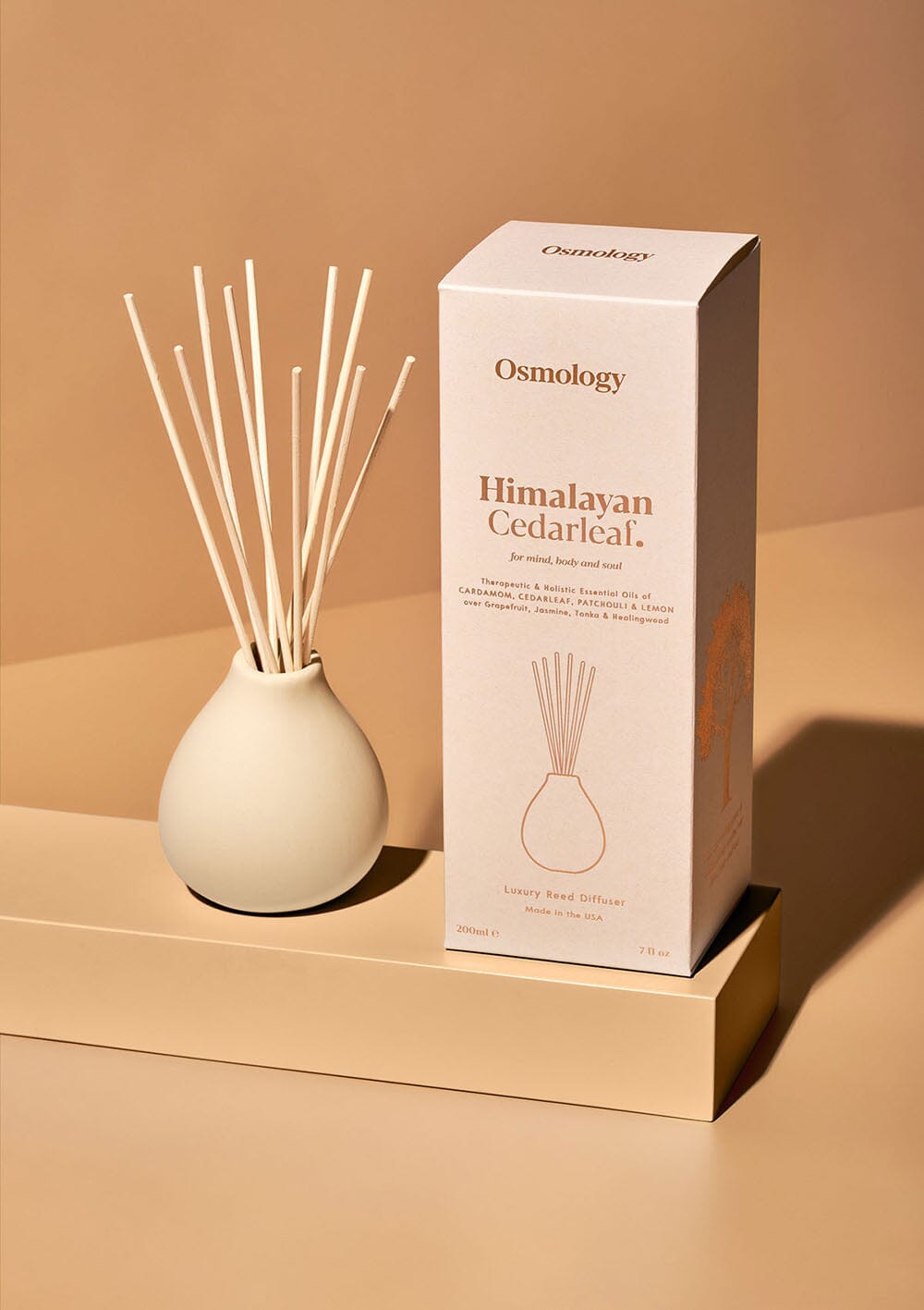 Osmology Himalayan Cedarleaf reed diffuser cream clay reed diffuser next to product packaging on a white background