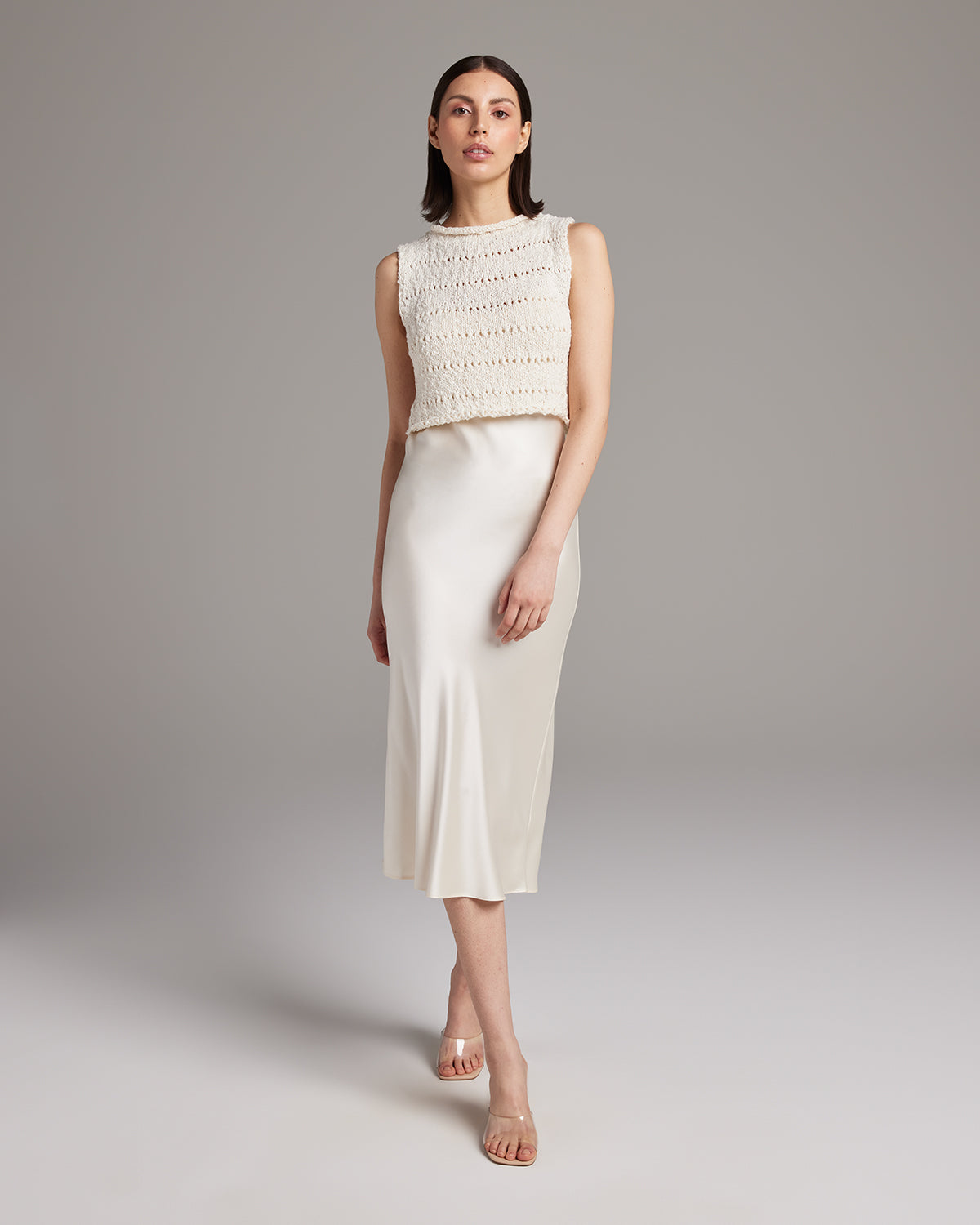 Model wearing a hand-knit Flammé crop top with a satin skirt