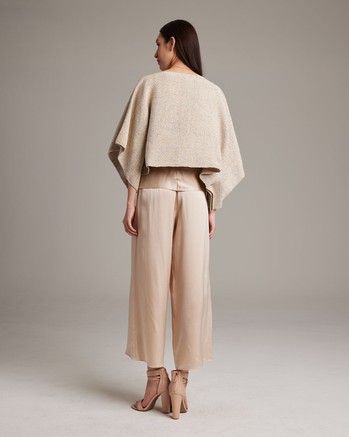 Model wearing a Pearl Crop Top from the back, paired with beige pants.