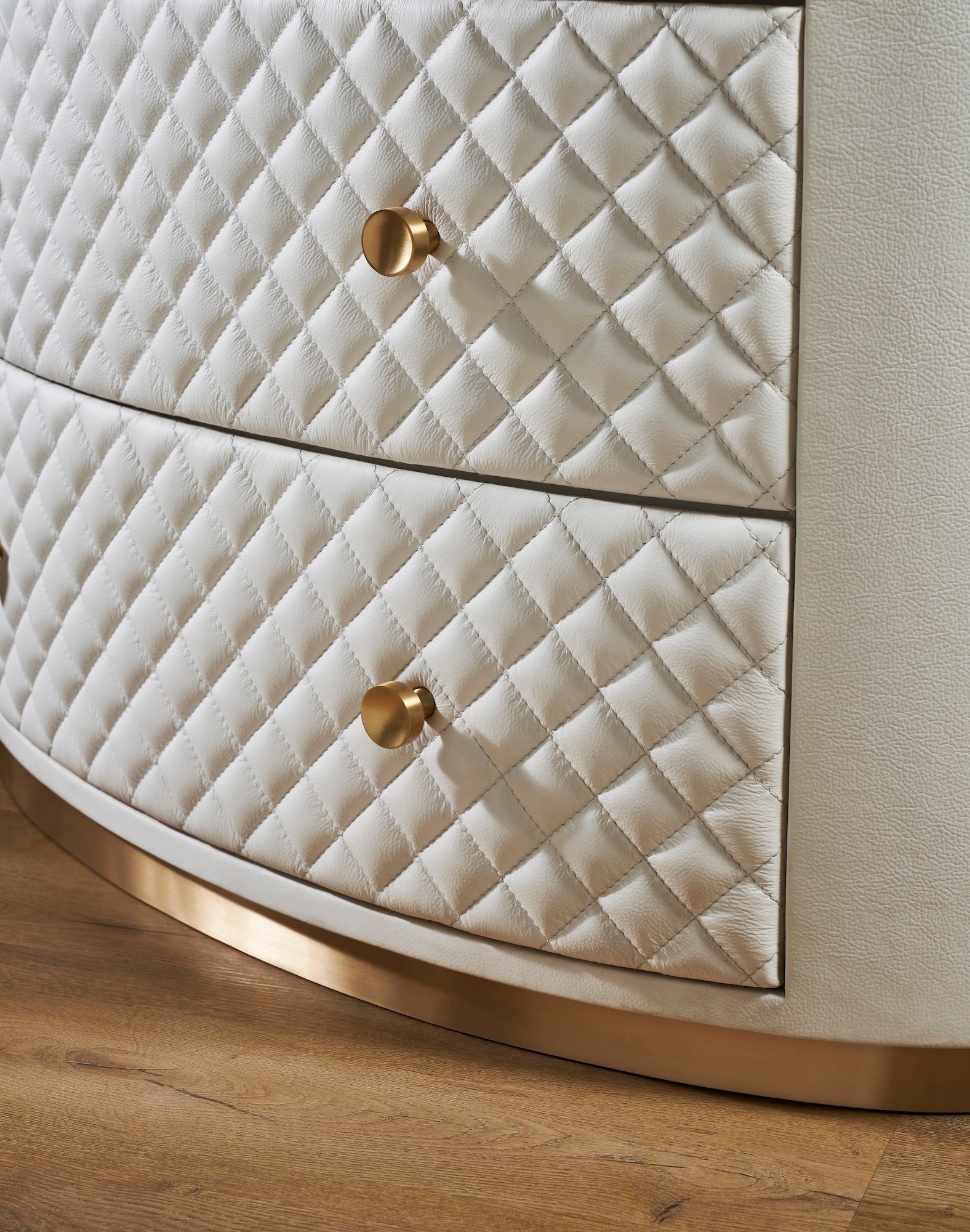 FN-5218-482036_5|Elegant white leather oval chest of drawers, featuring a chic quilted design, radiant gold hardware, and a sleek gold base.