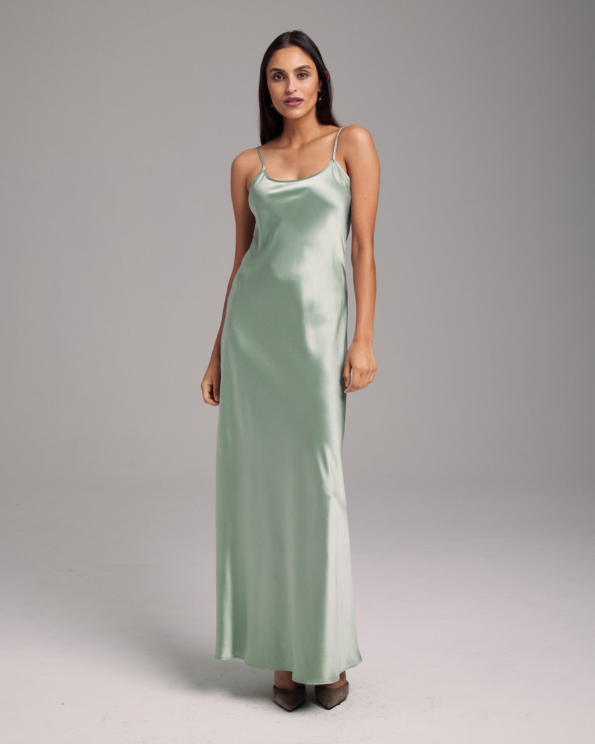 Model wearing a sage Liquid Silk Slipdress, showcasing its elegant drape.