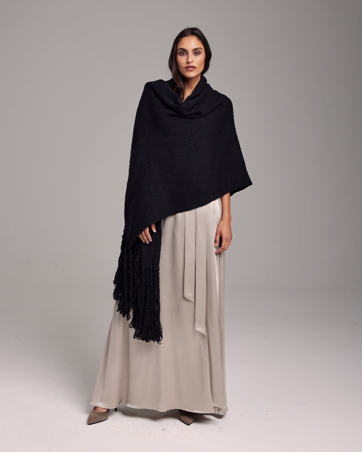 Model wearing a black Flammé Fringe Wrap shawl with fringe detail