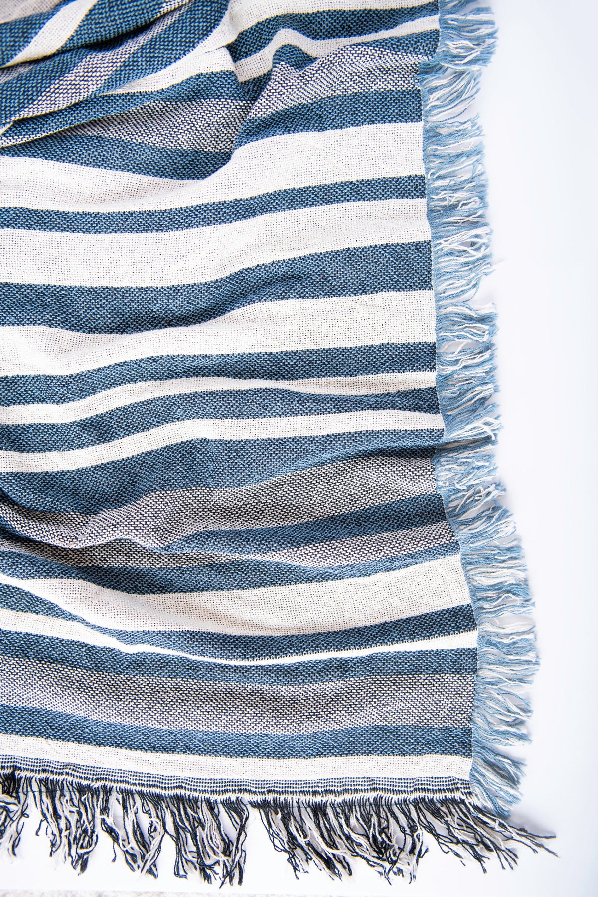 Close-up of the varied blue and cream stripes and fringe on Sutton Delft