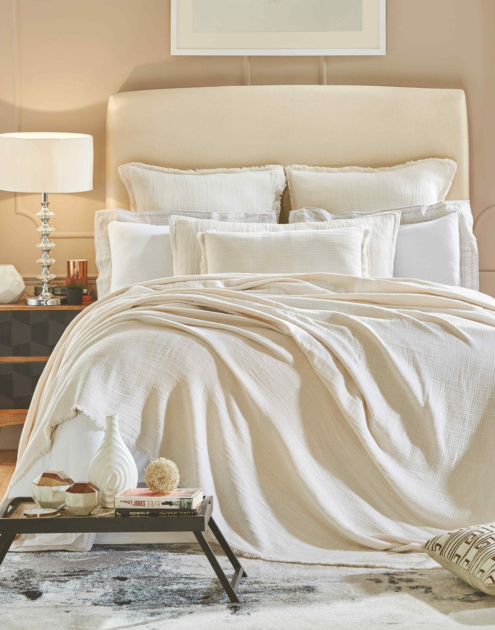 BT-103-11096_4|Cream textured blanket draped over a bed with decorative pillows, enhancing a cozy and inviting bedroom setting for comfort.