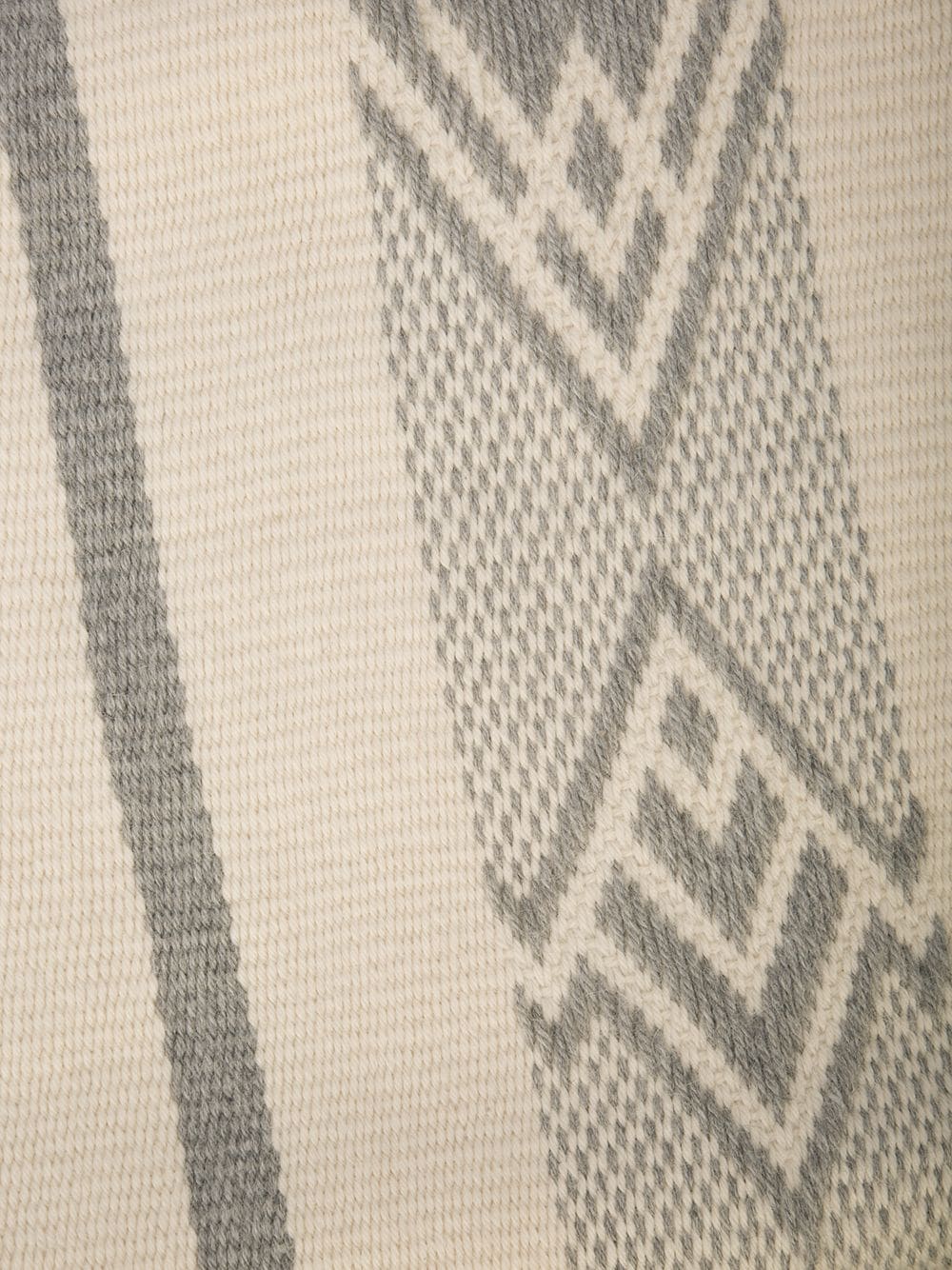 Close-up of a Wide Diagonal Alpaca Wrap featuring a geometric pattern in ivory and grey.