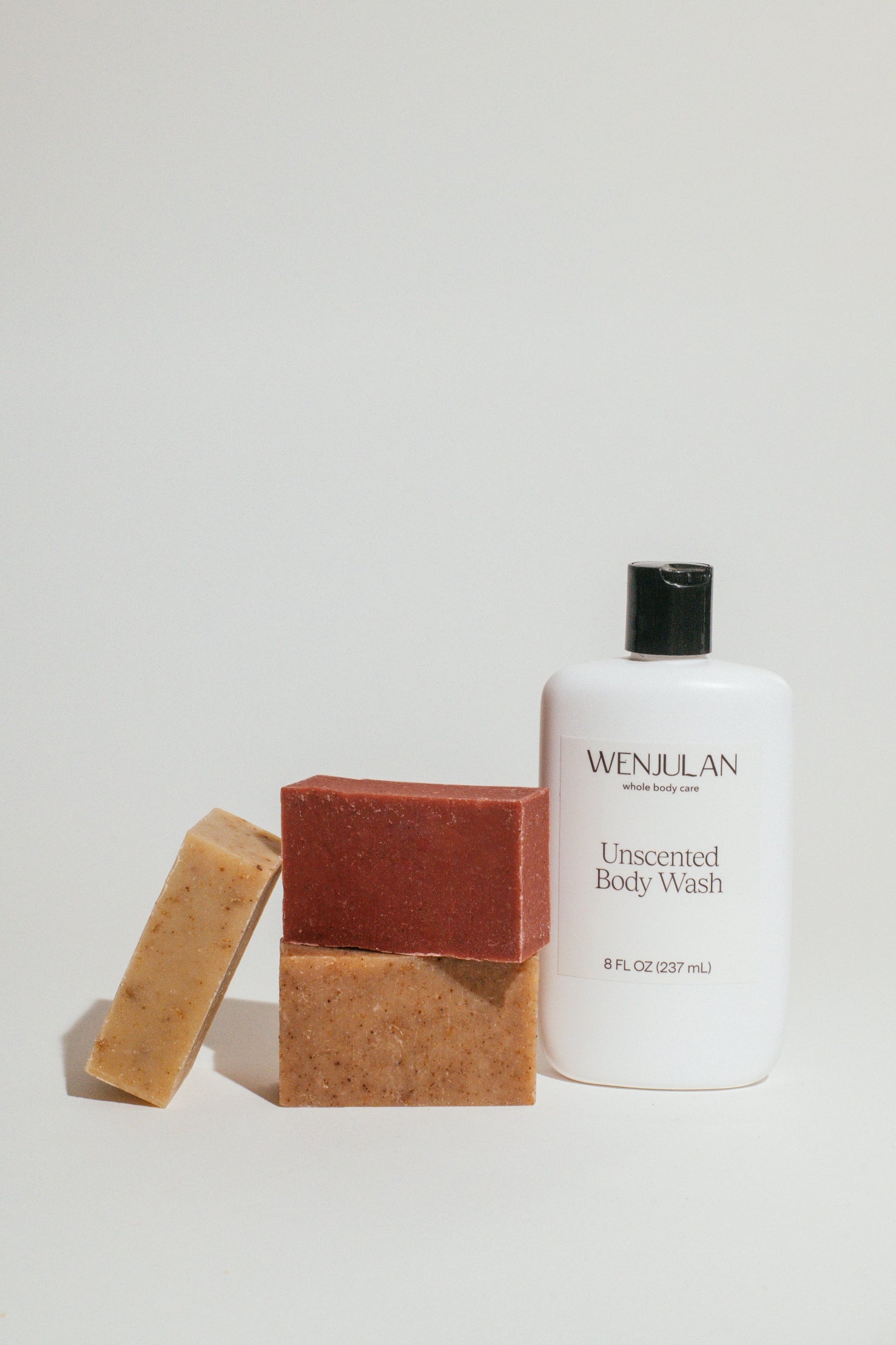 Wenjulan Whole Body Care Complete Care Collection bundle gift pack featuring Wenjulan Unscented Cleansing Soap with Colloidal Oatmeal bar, Wenjulan Sensitive Skin Cleansing Soap with Kaolin Clay bar, Wenjulan Southwest Cedar Cleansing Soap bar, Wenjulan Unscented Body Wash liquid soap on a light gray background