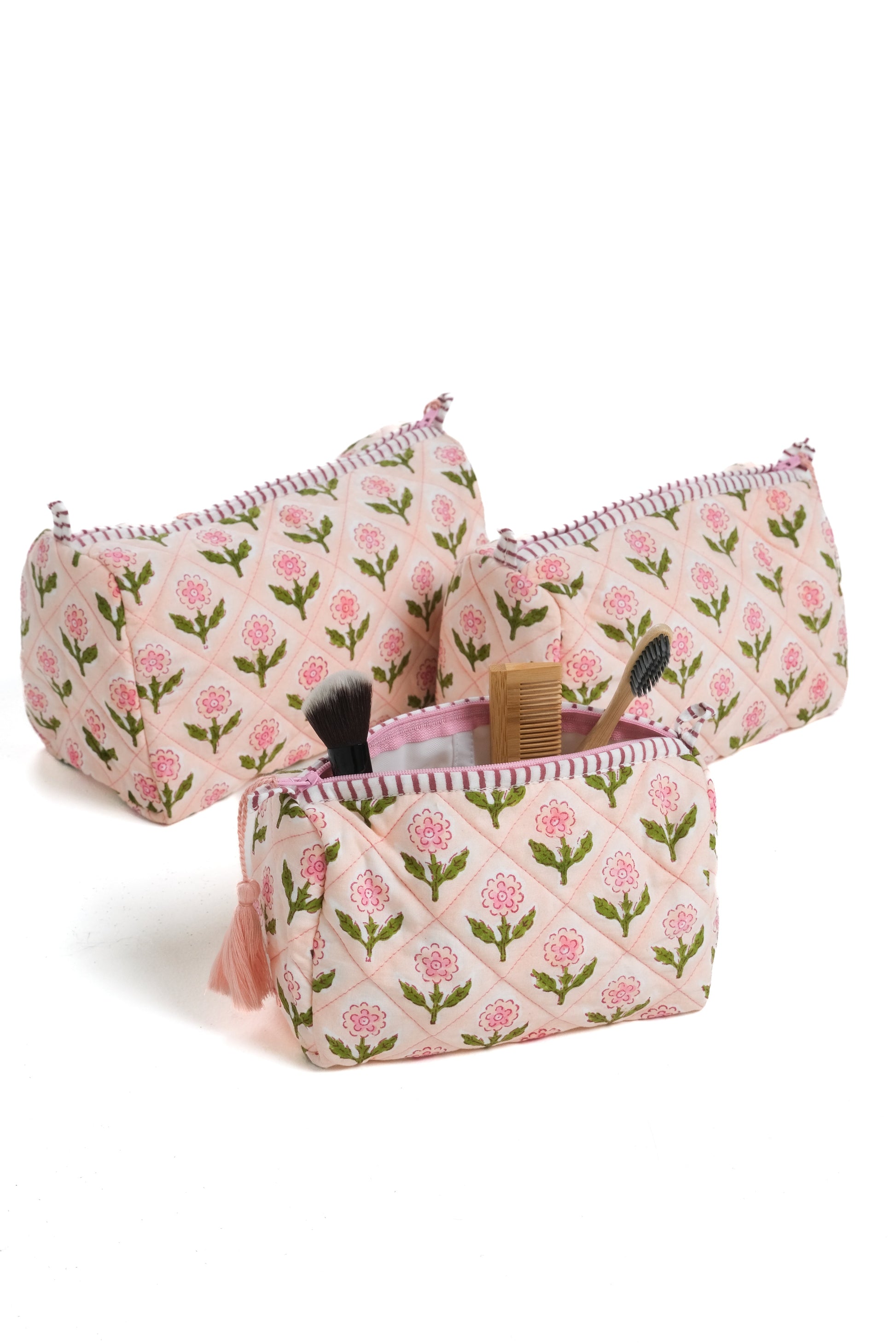 Pink blockprint makeup bags holding brushes and comb