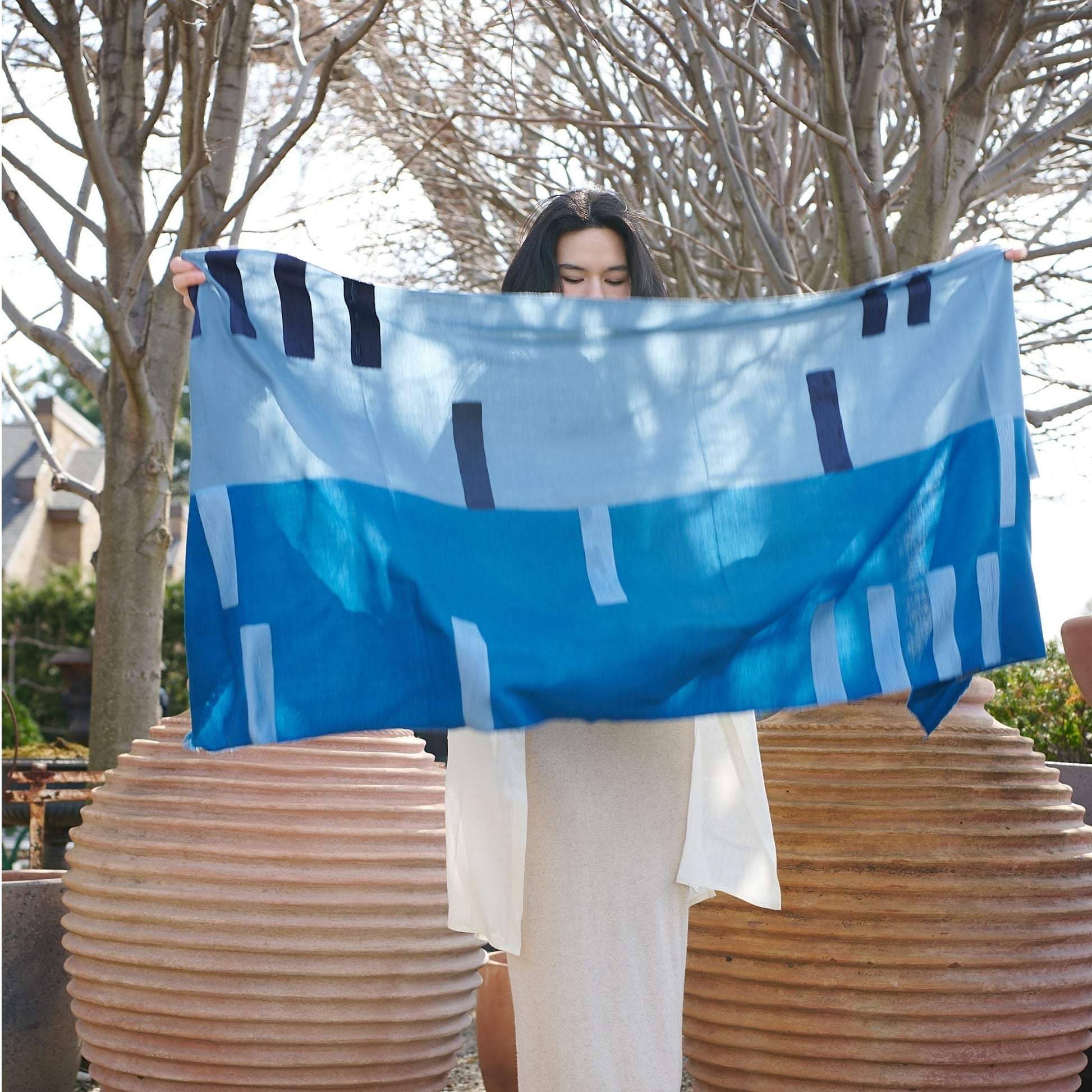 Harbor Blue Silk Merino Hand Woven Hand Embroidered Modern Artisanal Scarf displayed outdoors by a model.