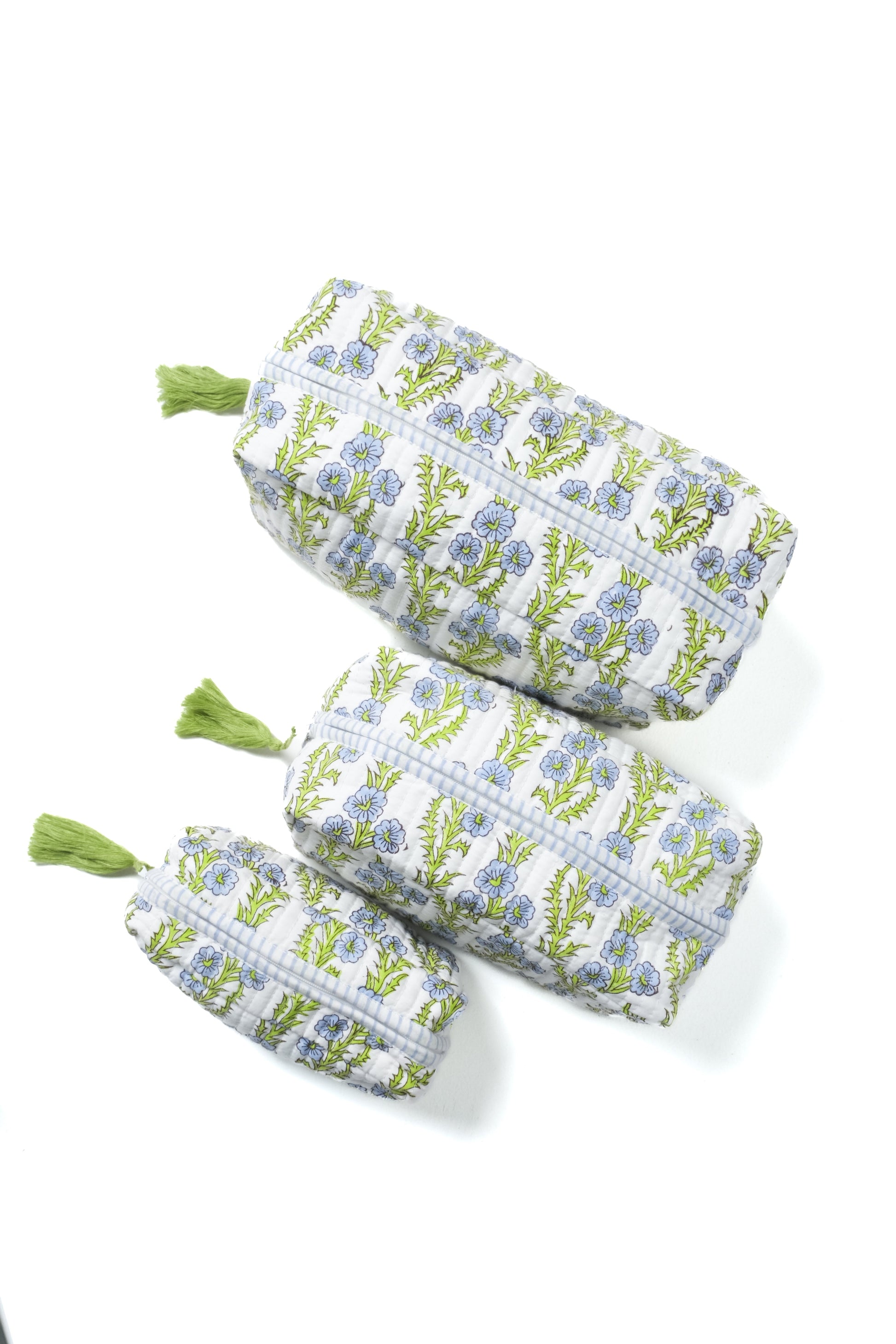 Set of blue blockprint makeup bags with forget-me-not floral pattern, green tassels
