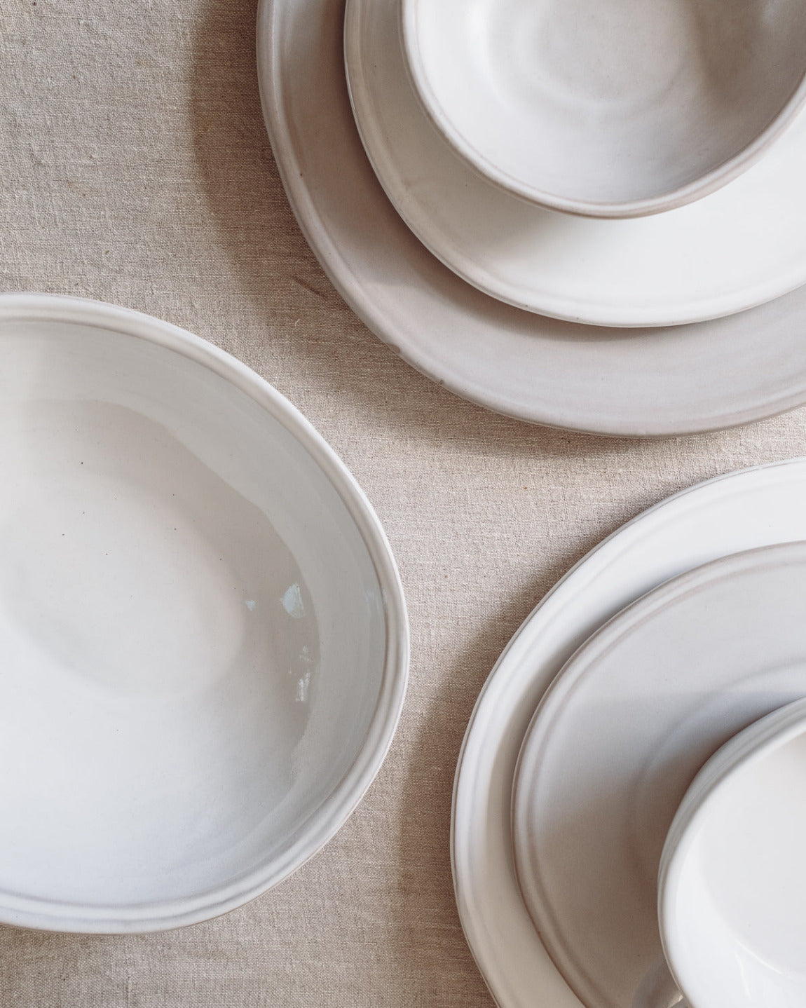 Set of white ceramic bowls on a beige surface