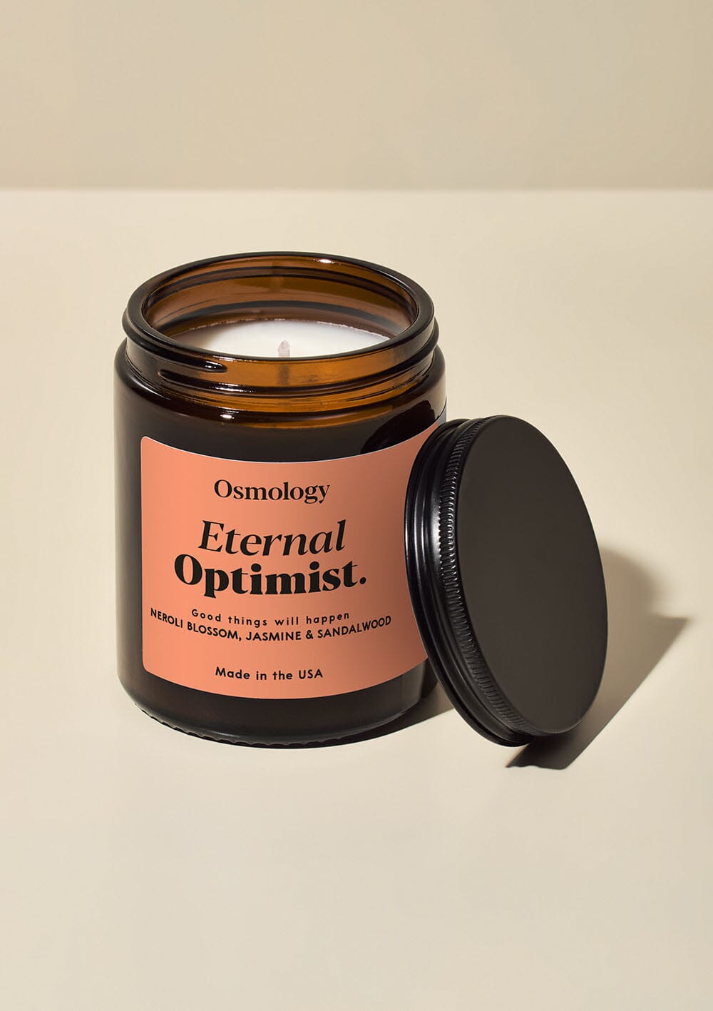 Osmology Eternal Optimist scented jar candle and lid on white background