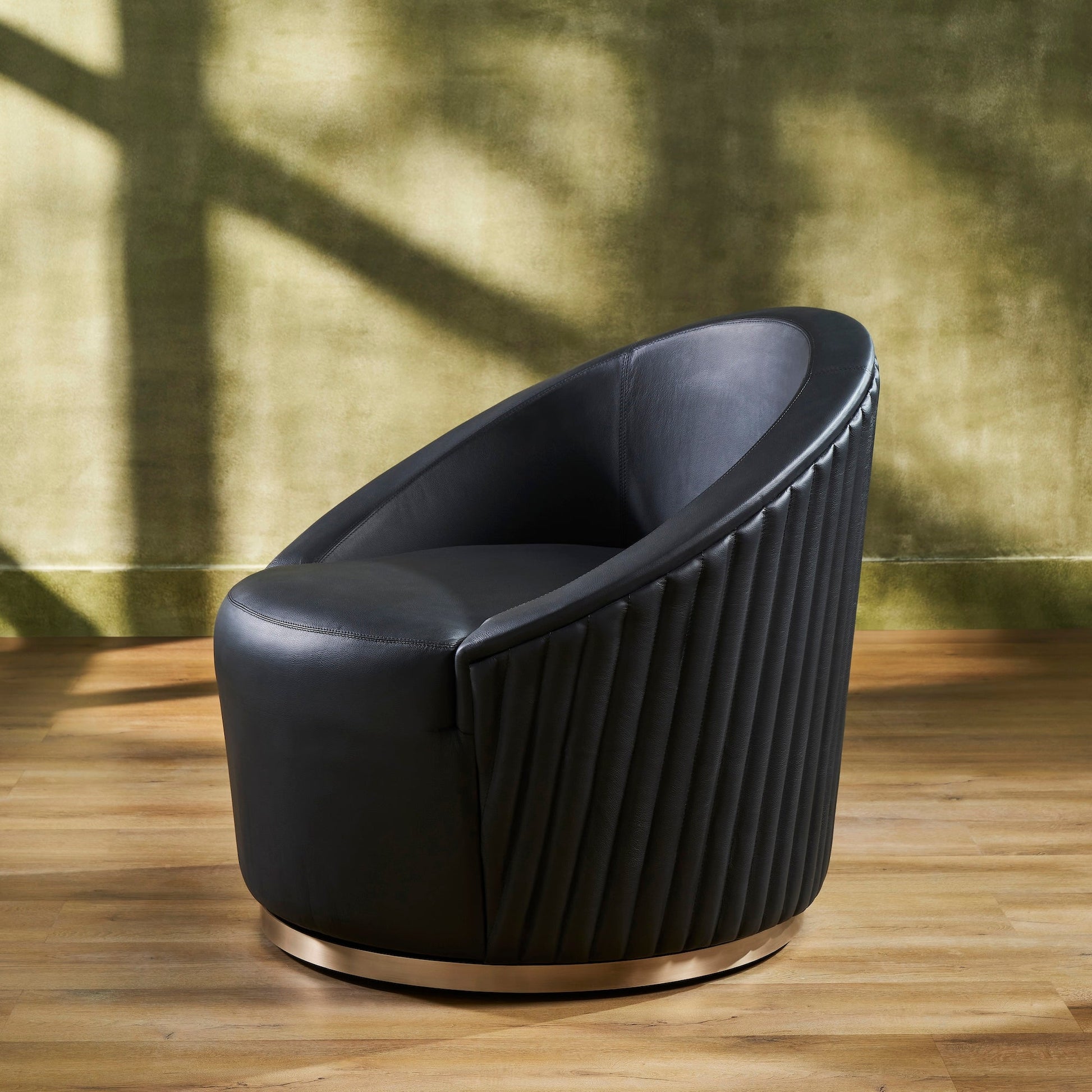 FN-5207-353529_3|Stylish black leather swivel armchair showcasing distinctive vertical ribbed texture on side and a chic round gold metal base.