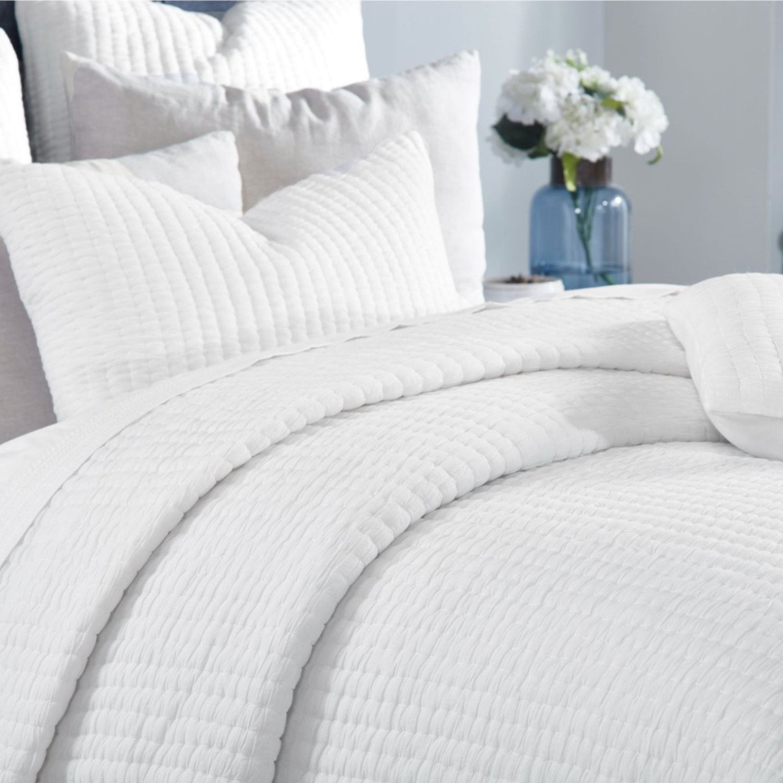 QT-358-9496_4|Close-up of a luxurious white quilted blanket with subtle textured stripes, showcasing comfort and pristine elegance.