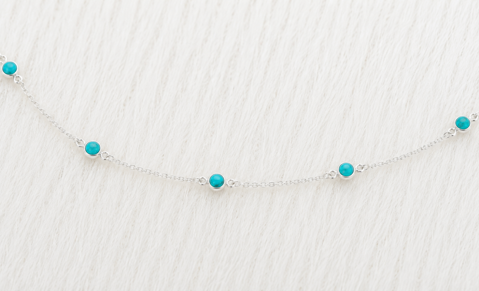 Silver necklace with turquoise beads on a Zuvan jewelry box