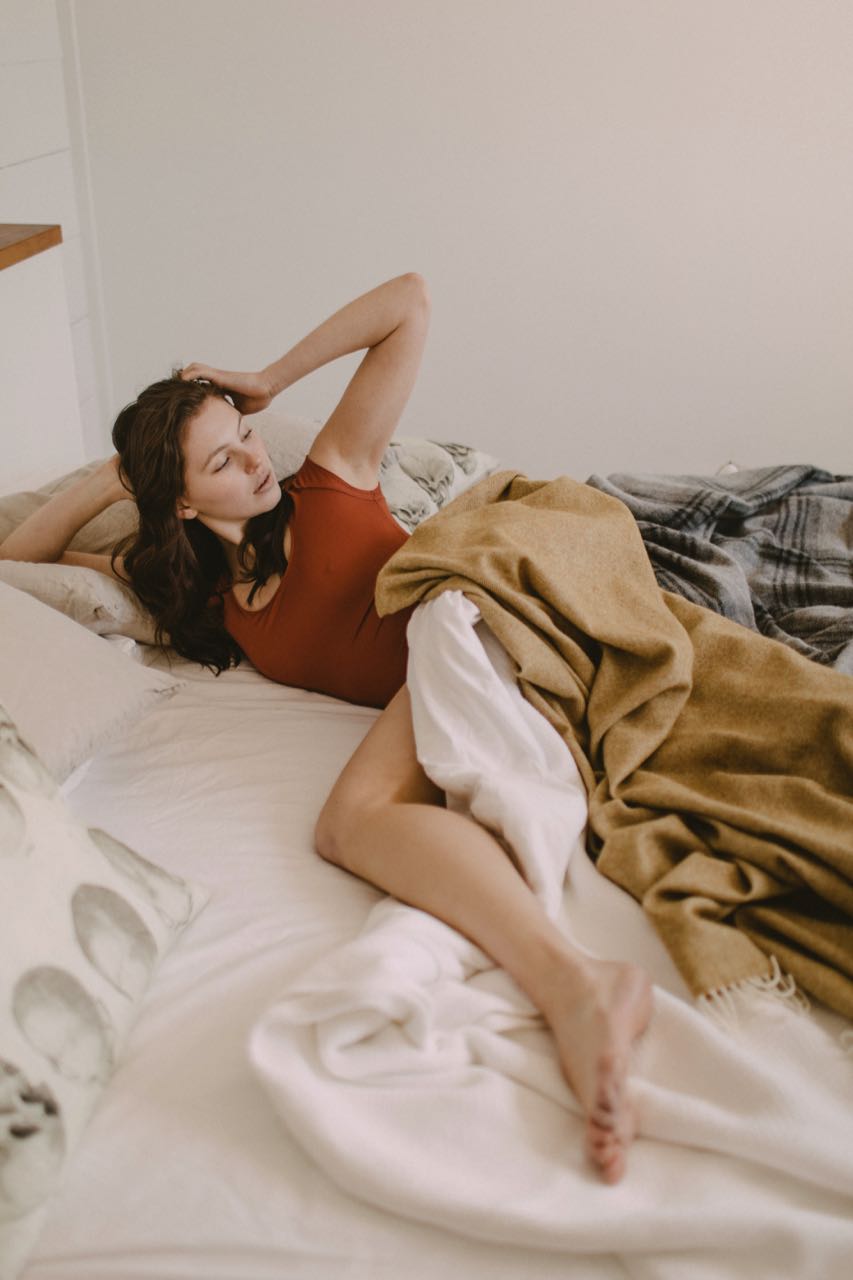 Indulge in opulence with a vision of elegance—a woman luxuriating on her bed, enveloped in the softness of an Evangeline linens blanket. This 100% Cotton, woven masterpiece, with its plain weave and enduring durability, is both washable and destined to become a cherished heirloom.
