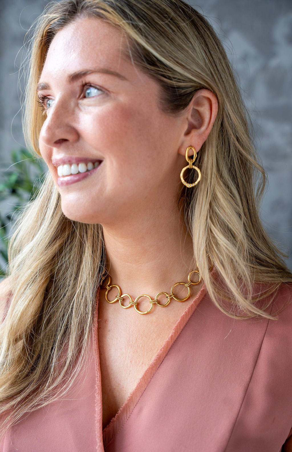 Large matte gold drop earrings with linked sculpted circles, rope-textured connector, and CZ stone accents on lower ring.
