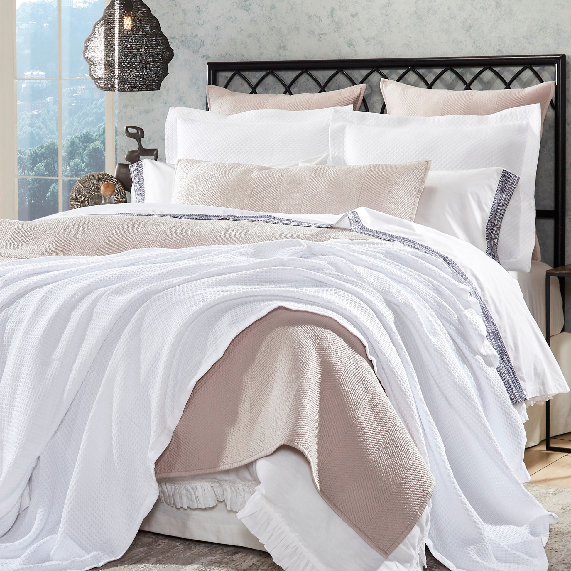BL-855-9496_1|Elegant white waffle weave blanket layered with a cozy light pink throw on a stylish bed, perfect for a modern bedroom.