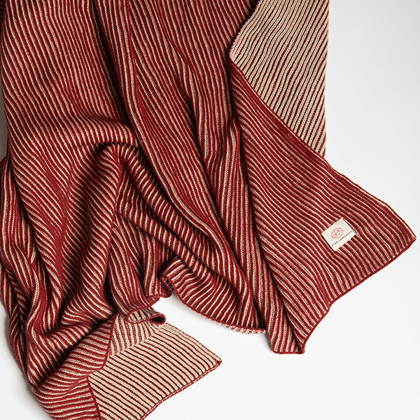 Red and beige striped marsala cotton throw with a Pink Lemonade brand label stitched in the corner laid on a white background.