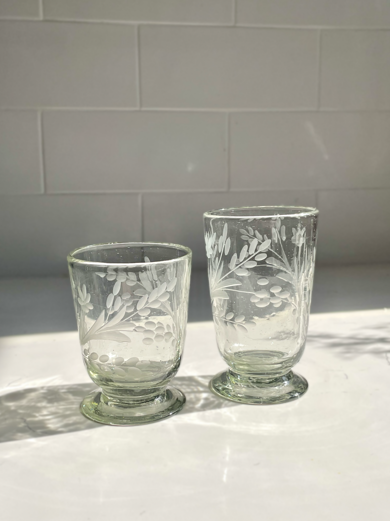 Hand-etched blown footed glass made from recycled glass with floral design, ideal for serving water, wine, or tea
